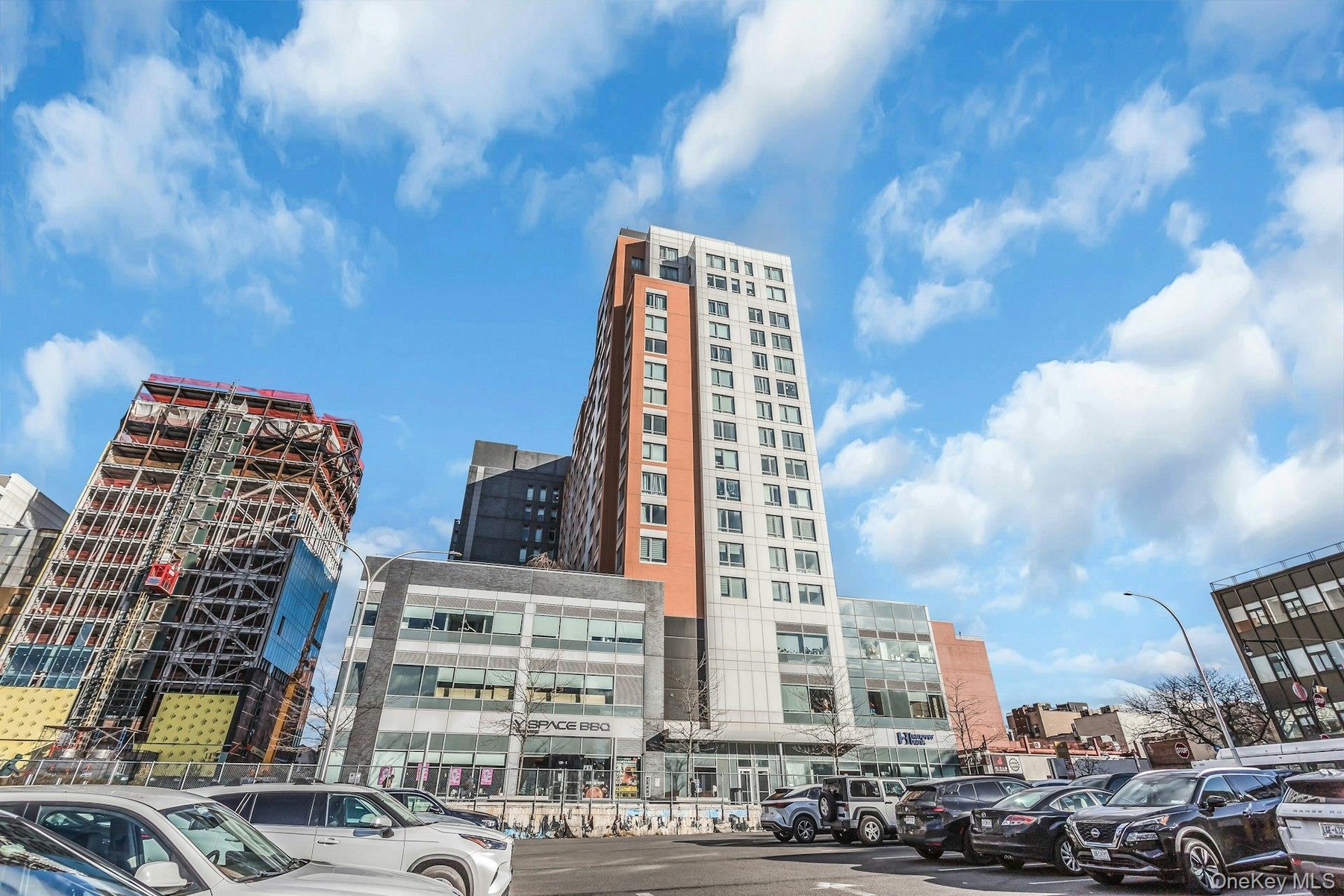 View of apartment building / complex with a city view and uncovered parking