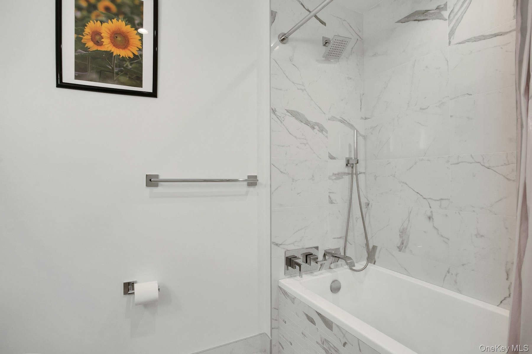 Full bath featuring a combined bath / shower with marble appearance