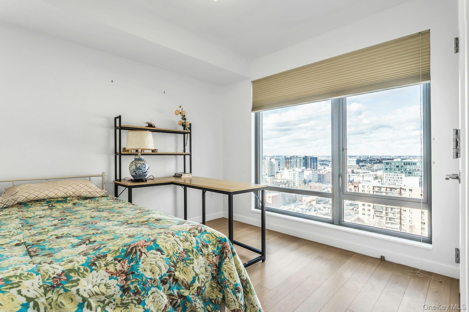 Bedroom featuring light wood-style floors and a view of city