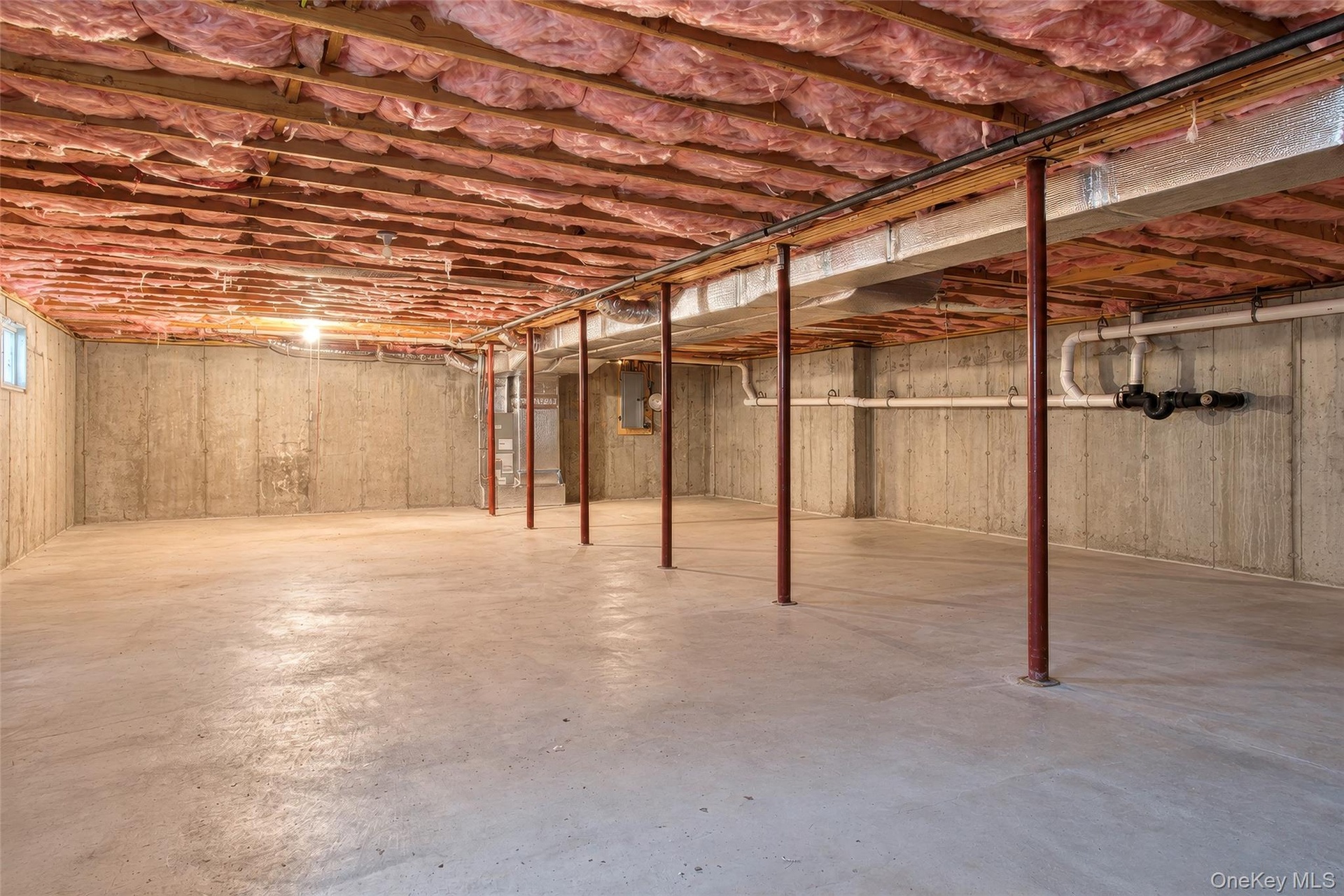Unfinished basement with concrete walls, concrete flooring, and visible insulation