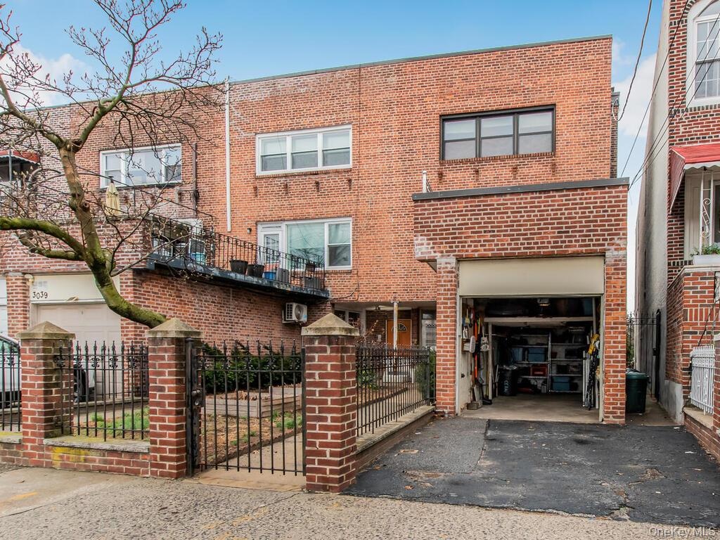 Multi unit property with aphalt driveway, an attached garage, fence, and brick siding