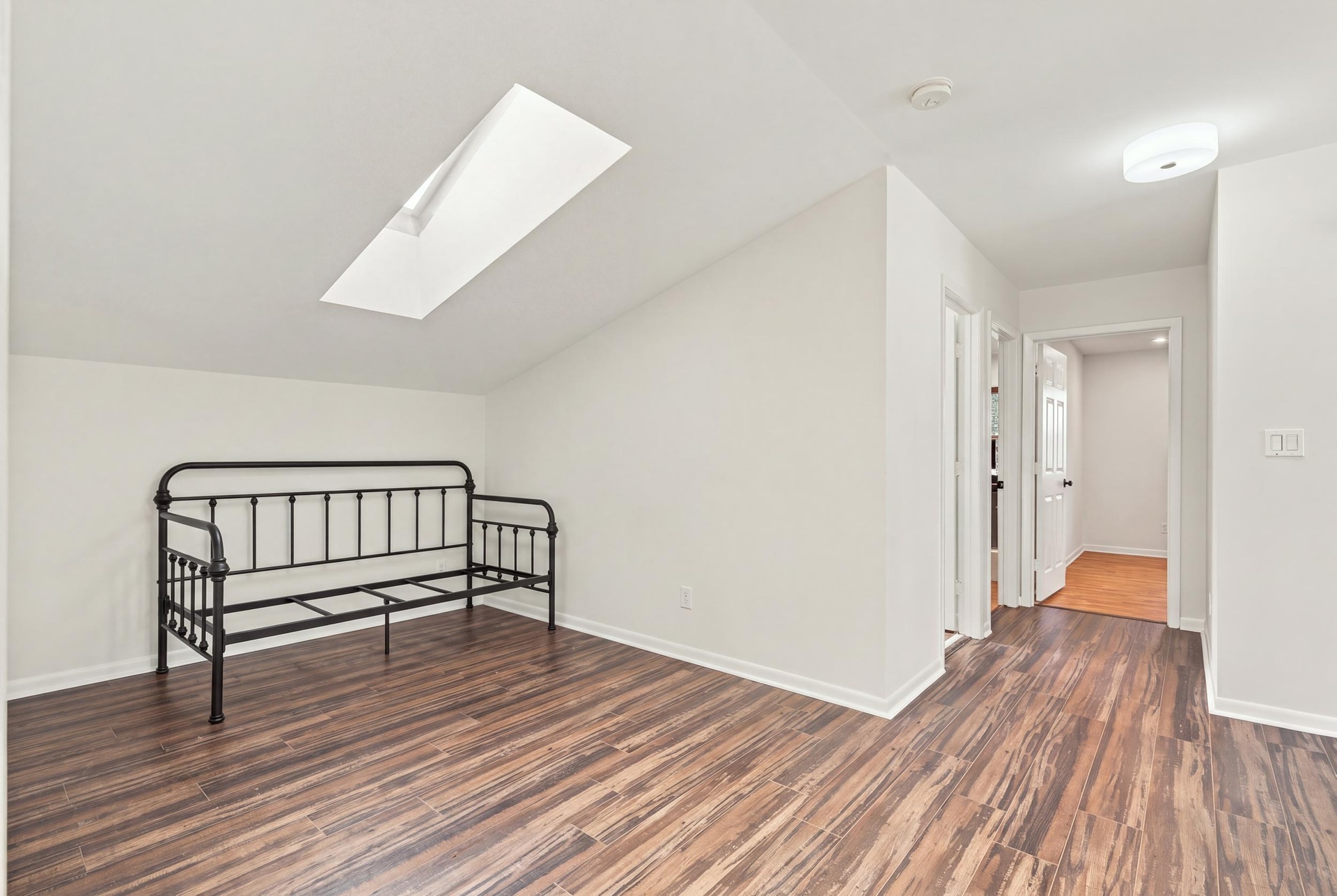 The upstairs loft offers valuable flexibility as a children’s playroom, private home office, or intimate lounge. A skylight fills the space with natur