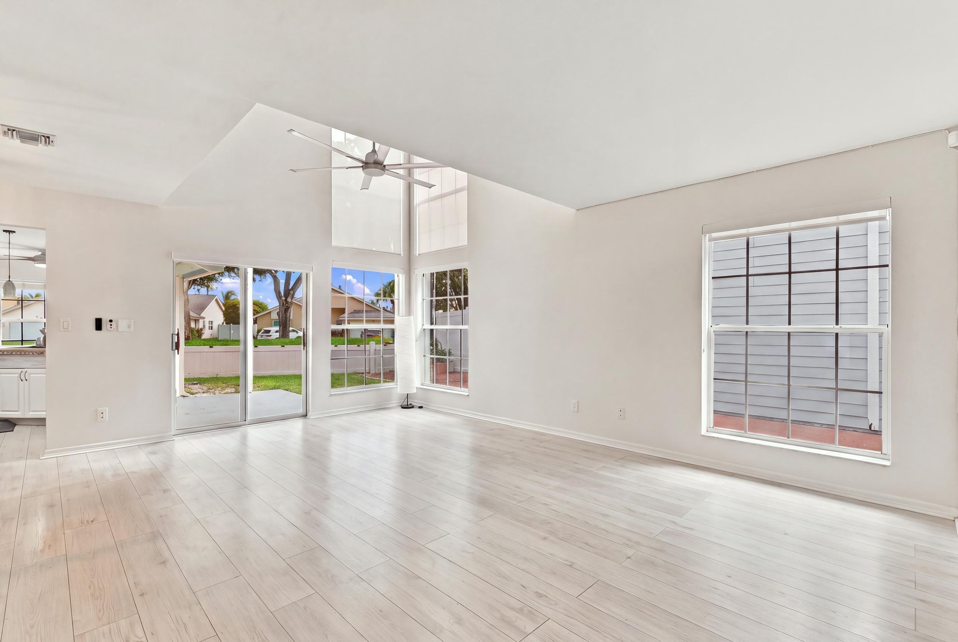 From the moment you enter, soaring ceilings and expansive windows fill the home with natural light, creating a bright, welcoming atmosphere that immed