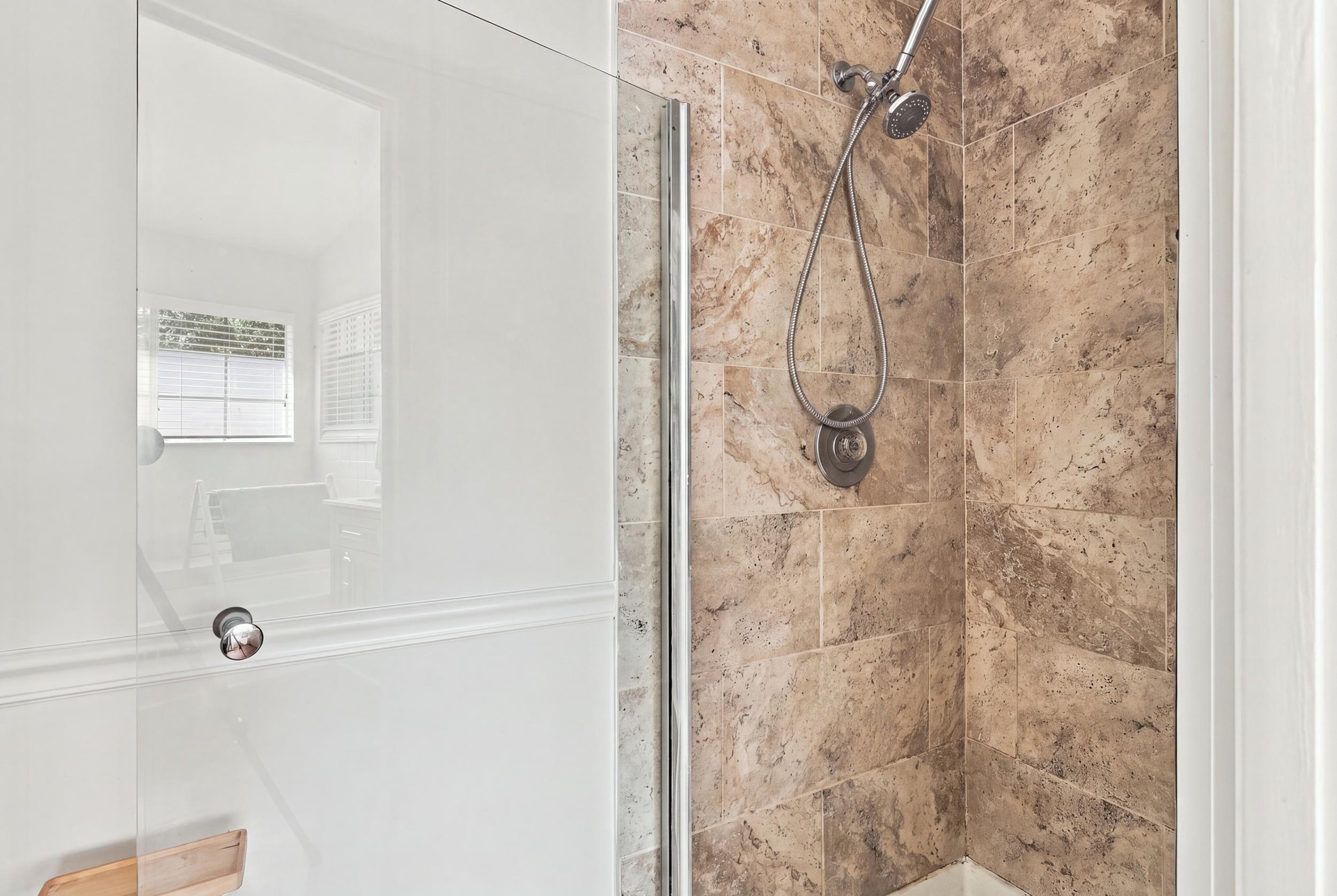 The fully updated primary ensuite exudes refined elegance with a natural oak vanity, quartz countertops, new fixtures, a relaxing bathtub, and a beaut