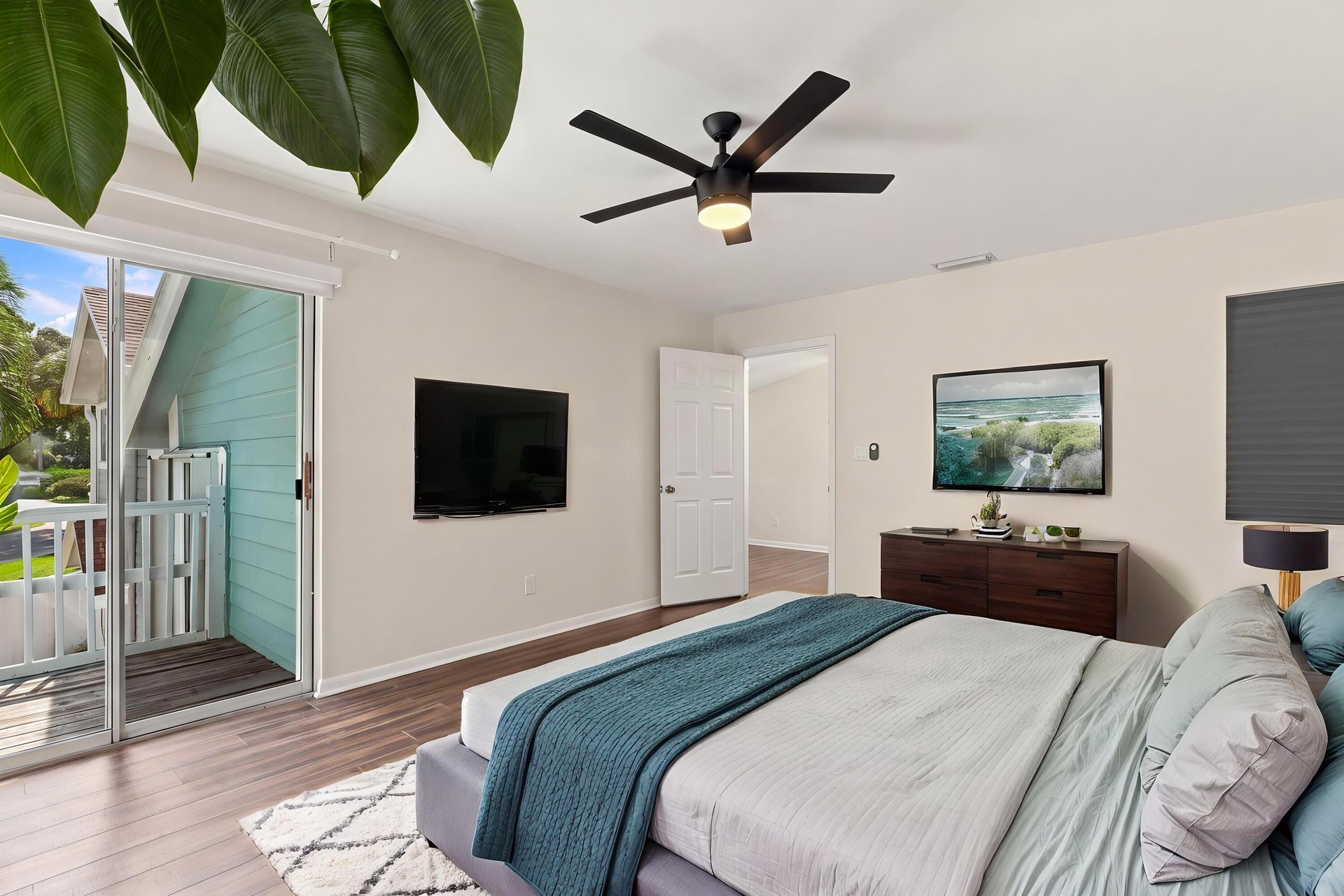 The elegant primary suite offers a private retreat with a beautifully updated bathroom, spacious walk-in closets, and a private balcony overlooking th