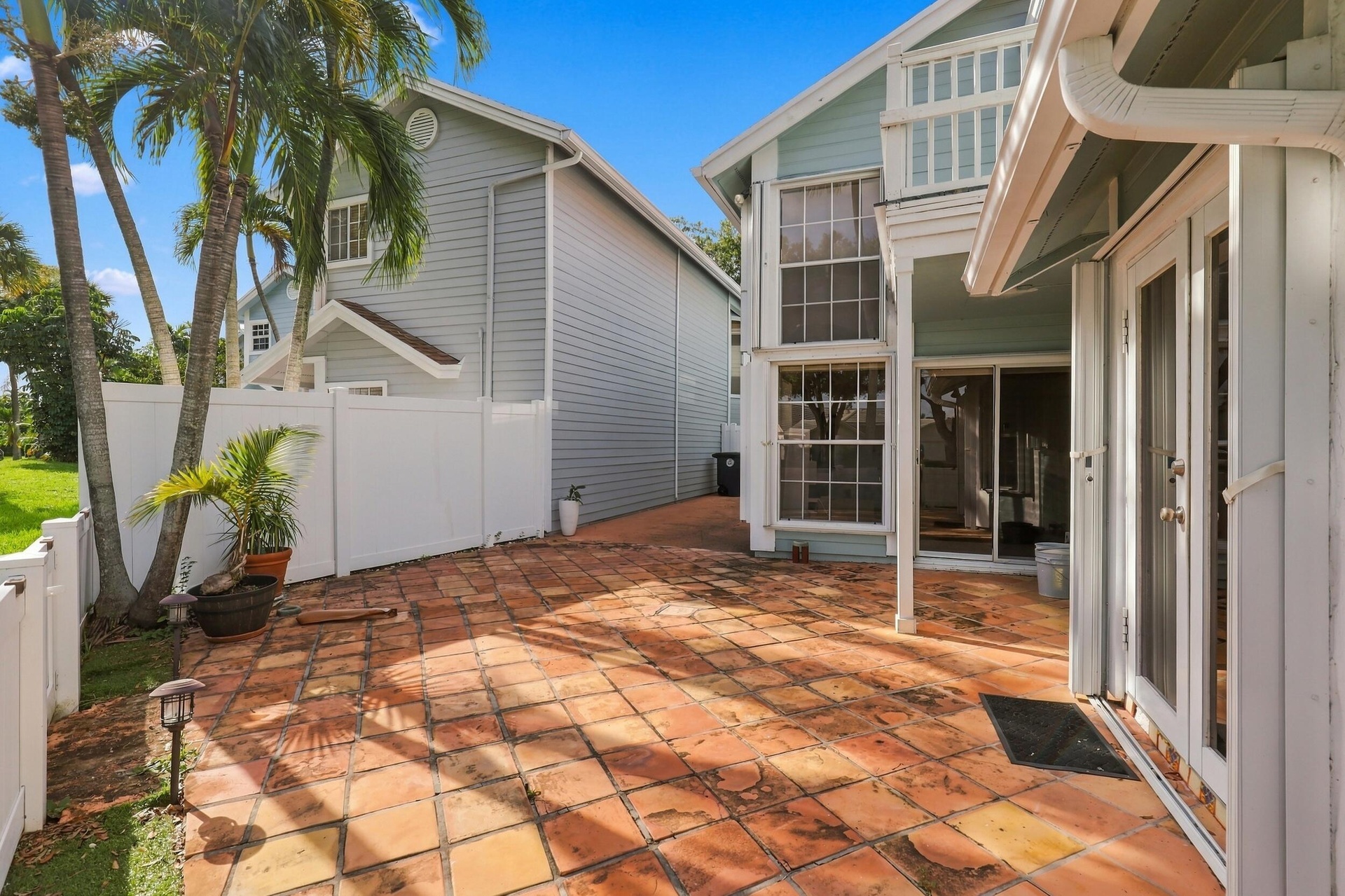 The private backyard is designed for effortless Florida living, featuring an expansive Spanish tile patio with a covered area for year-round enjoyment