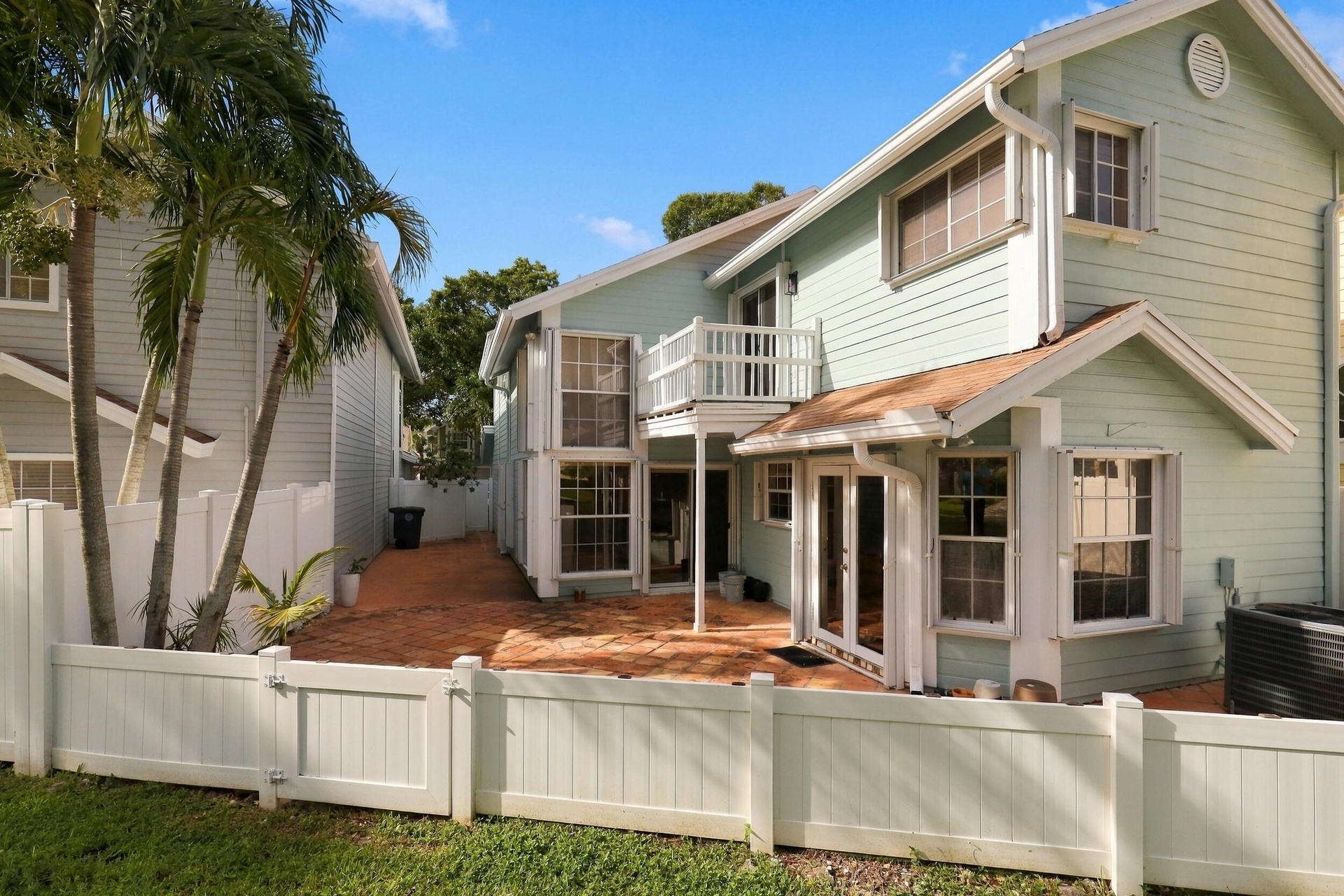 The private backyard is designed for effortless Florida living, featuring an expansive Spanish tile patio with a covered area for year-round enjoyment