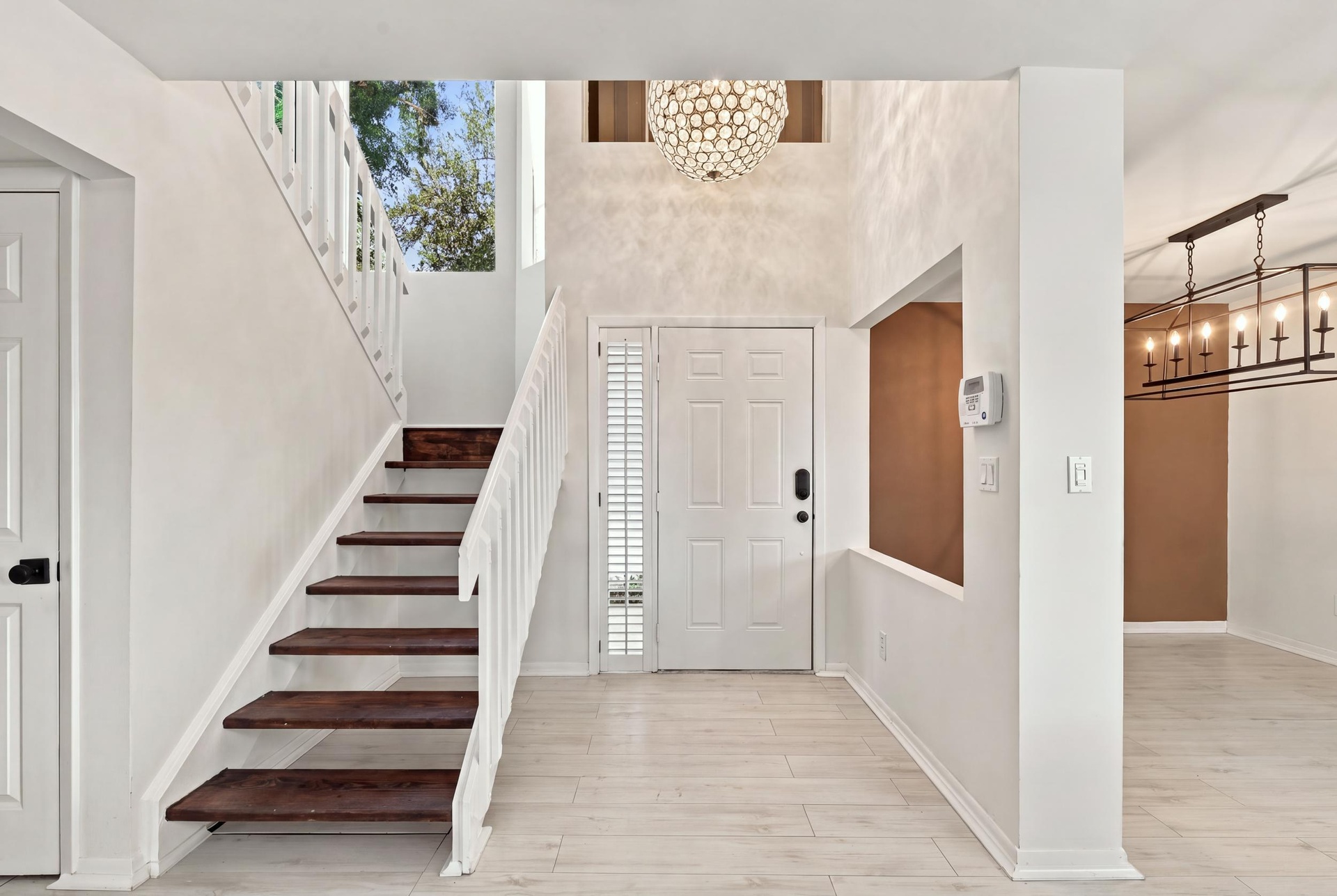 From the moment you enter, soaring ceilings and expansive windows fill the home with natural light, creating a bright, welcoming atmosphere that immed