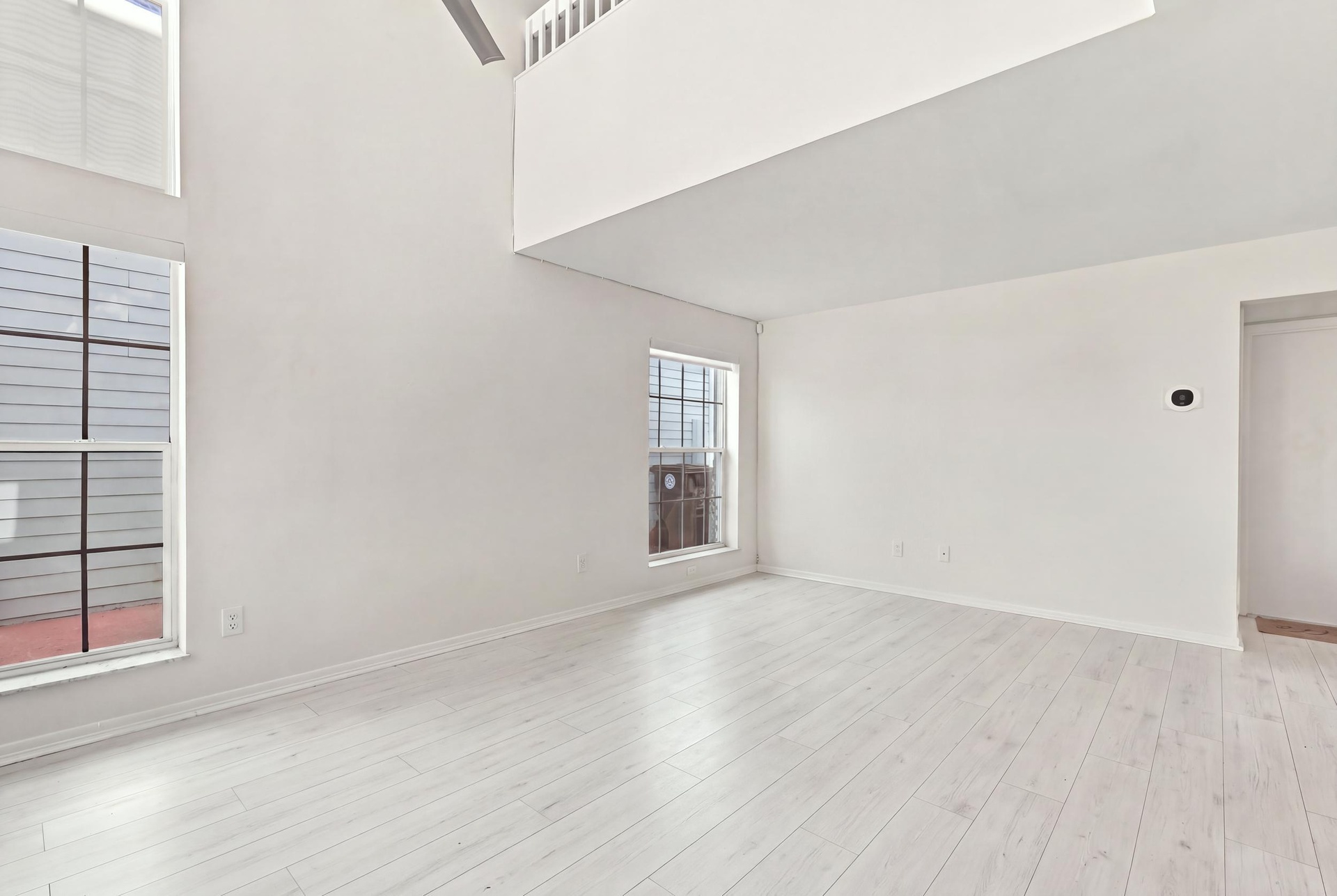 Soaring 15-foot ceilings and expansive windows fill the living room with natural light, creating a warm and welcoming space for everyday living and en
