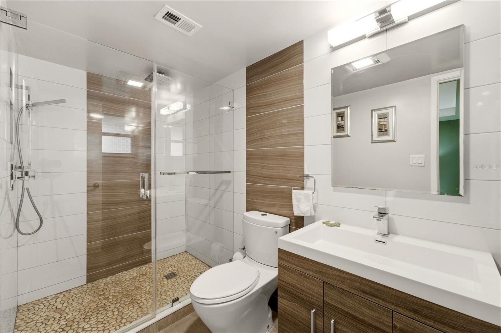 Contemporary bath featuring floor-to-ceiling tile and modern finishes.