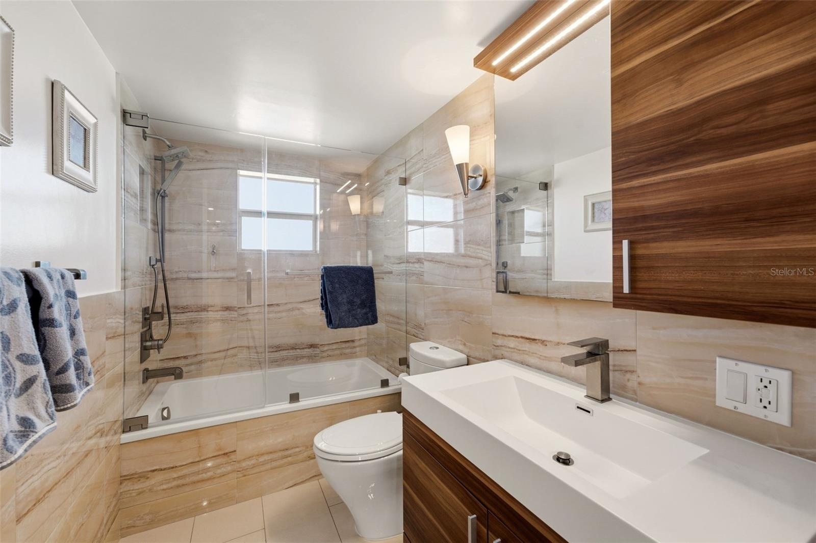 Contemporary bath with floor-to-ceiling tile and refined finishes.