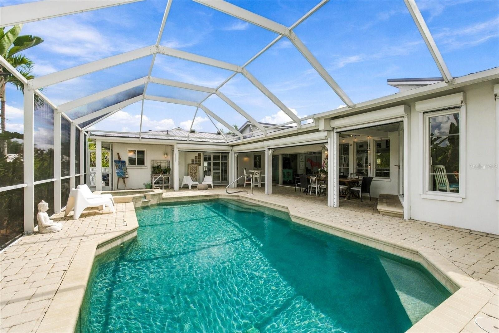 Automatic roll down hurricane shutters protect the covered pool area.