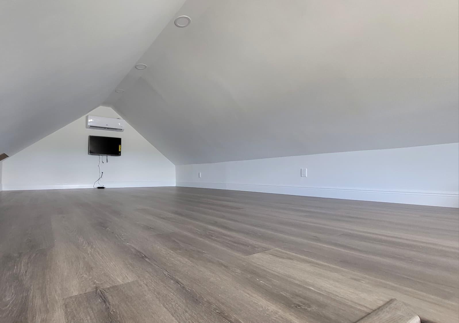 Wood-finish flooring, recessed ceiling lighting, and a built-in wall-mounted air conditioning unit