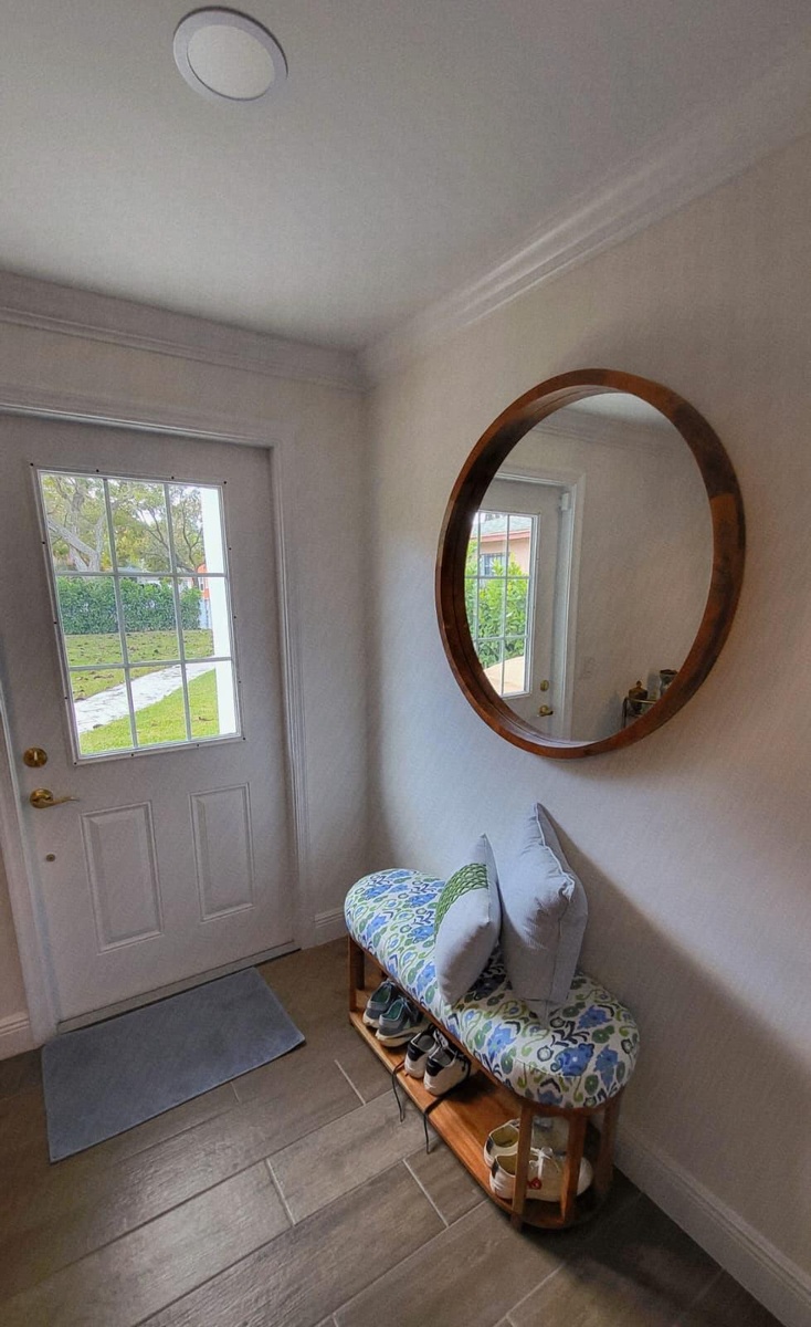 Recessed ceiling lighting, crown molding, paneled door with glass inserts, wood-finish flooring, and a round wall mirror