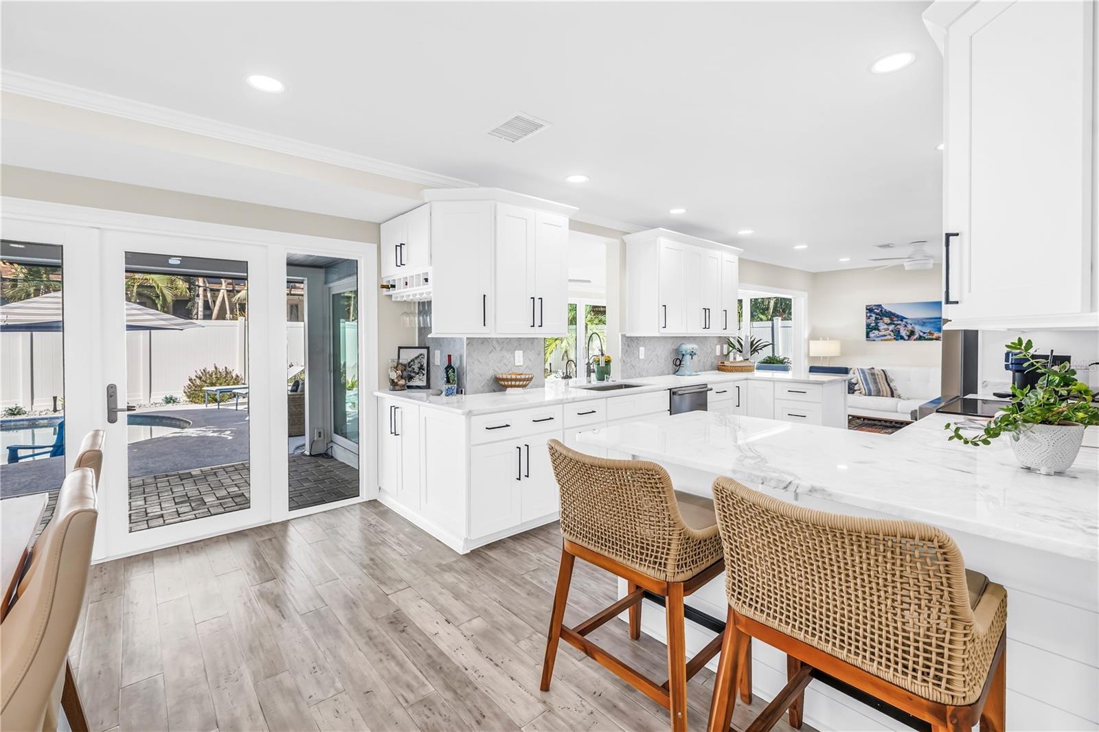 Casual seating to "help" the cook in this Showstopper Kitchen! Quartz countertops have a very light blue hue!