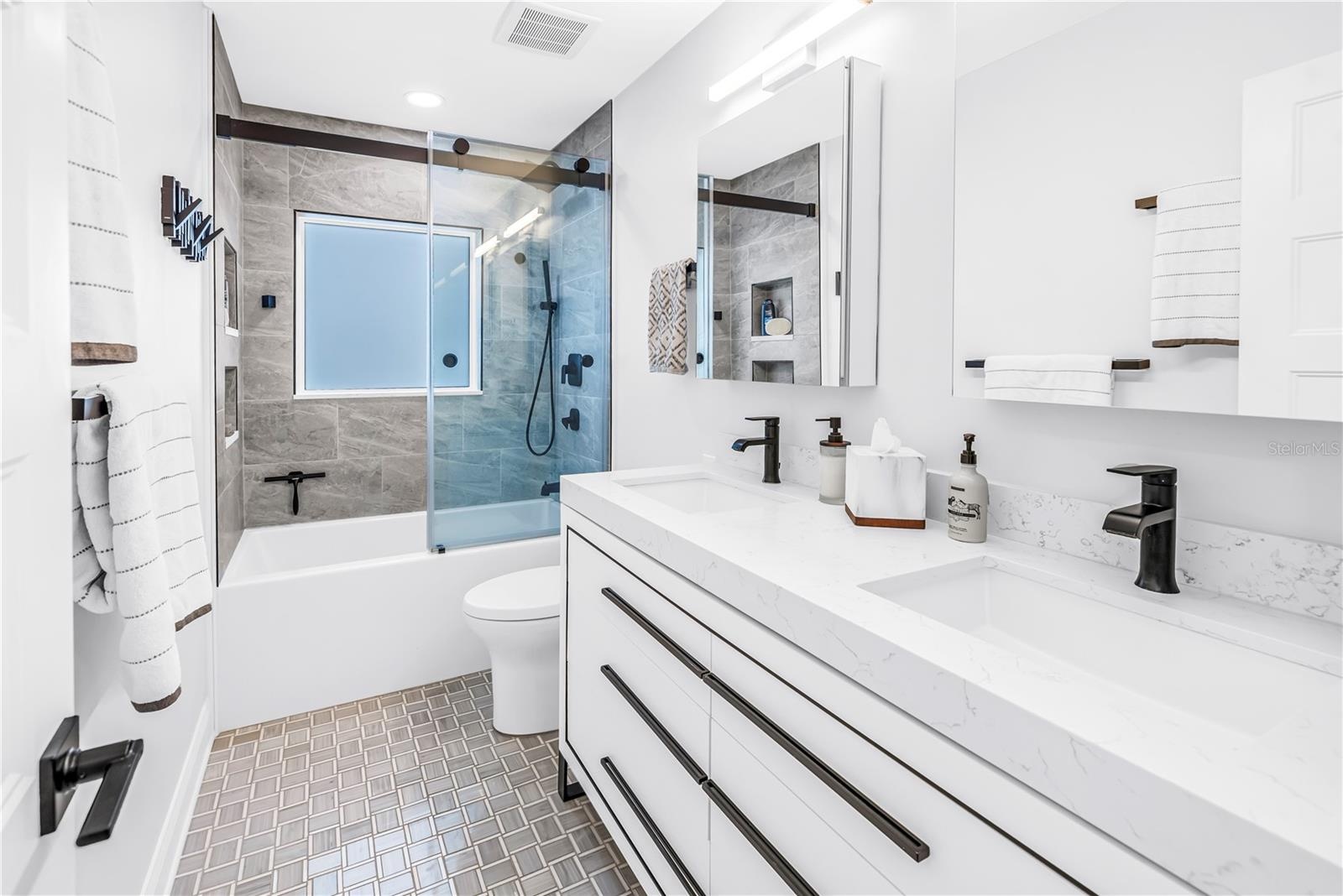 2nd bath with deep soaking tub, custom dual vanity with European style drawers, stone countertops, 2  Robern medicine cabinets, frosted glass window f