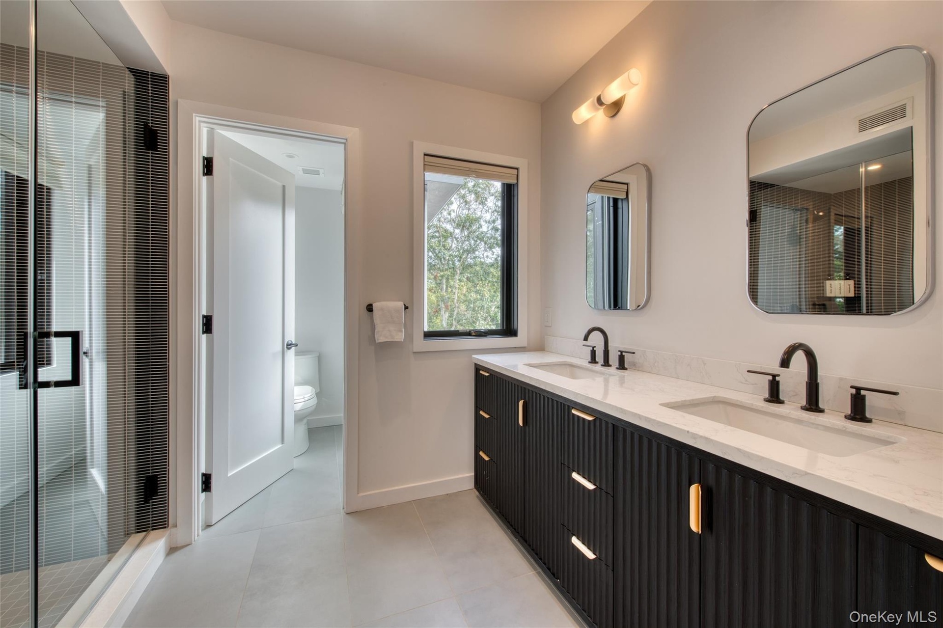 Dual vanity with integrated sinks, black fluted cabinetry, and matte black fixtures