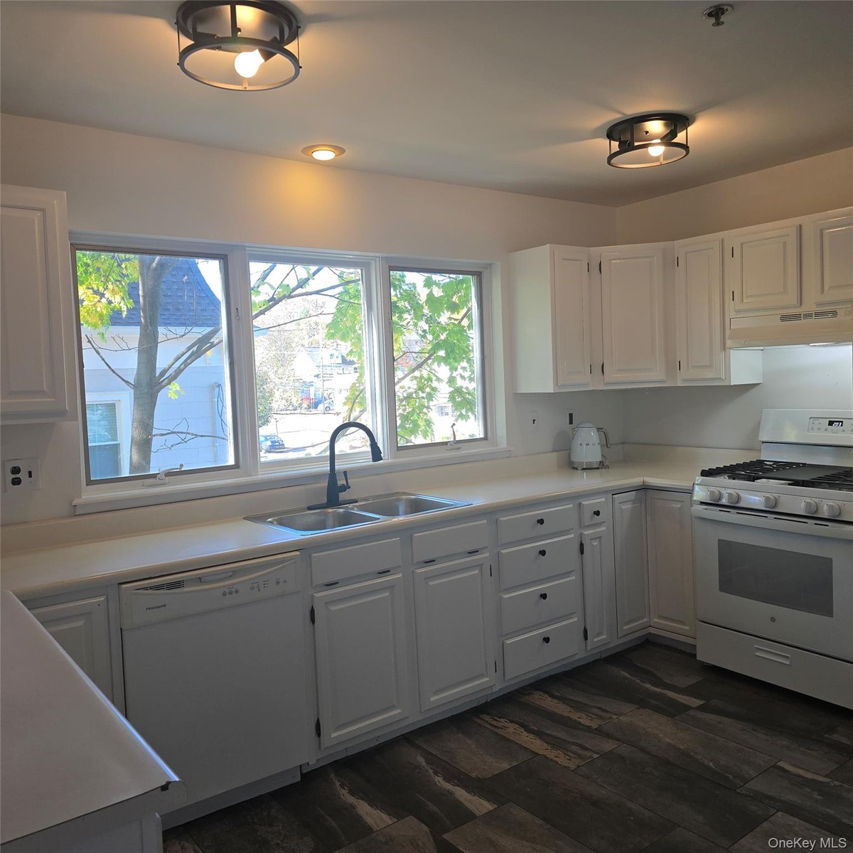 Kitchen with white cabinetry, extractor fan, dark hardwood / wood-style floors, sink, and white appliances