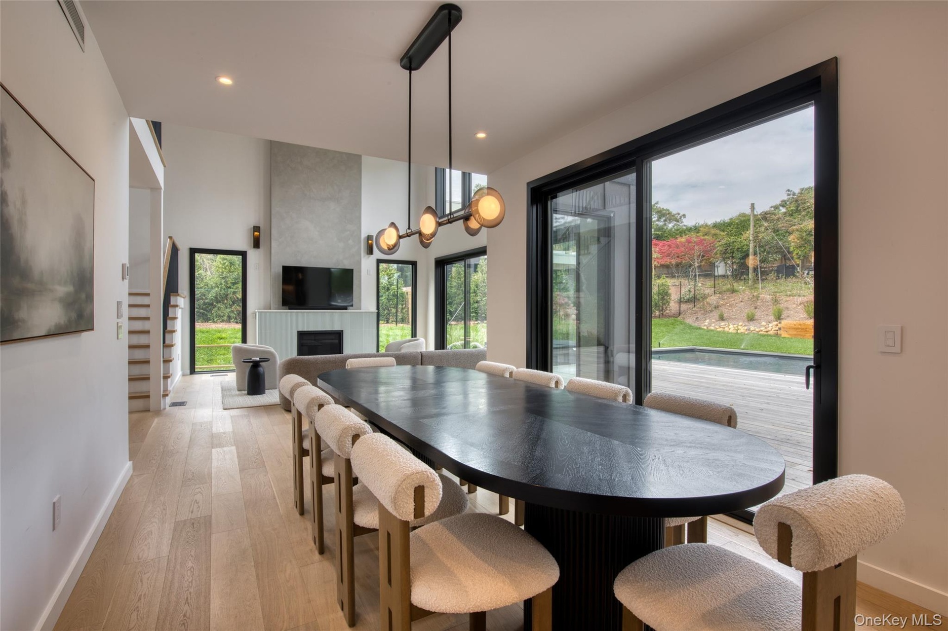 Spacious dining area featuring wood-finish flooring and a contemporary chandelier