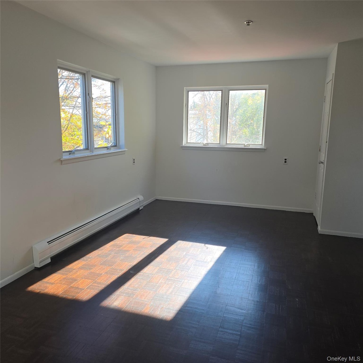Empty room featuring a baseboard heating unit
