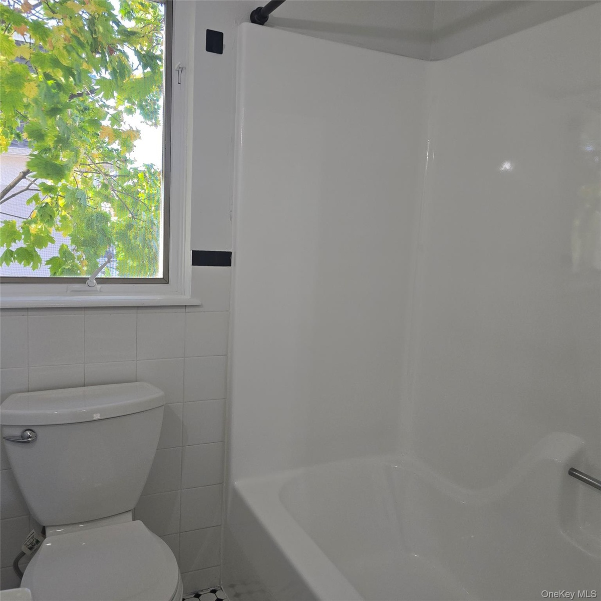 Bathroom with toilet and tile walls
