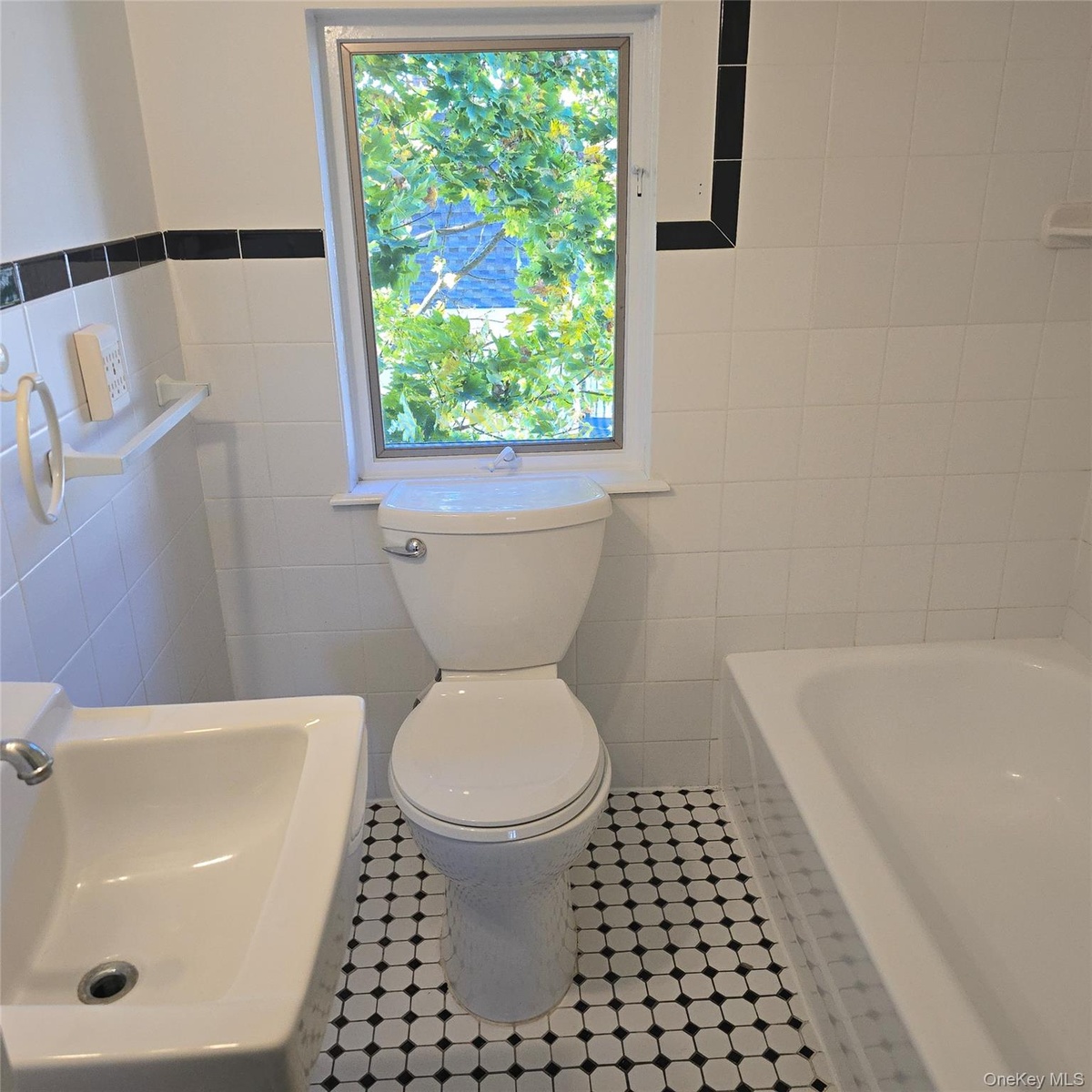 Bathroom with tile patterned floors, a bath, toilet, and tile walls