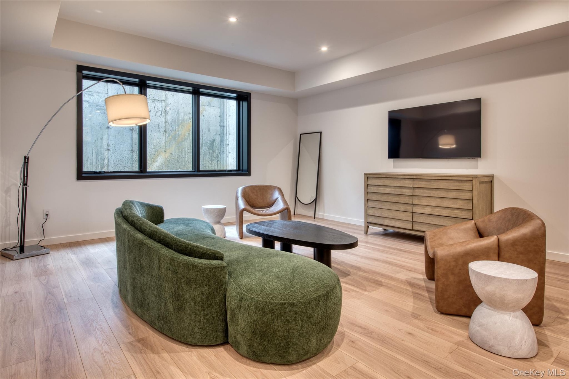 Recessed lighting, wood-finish flooring, and a window with black trim