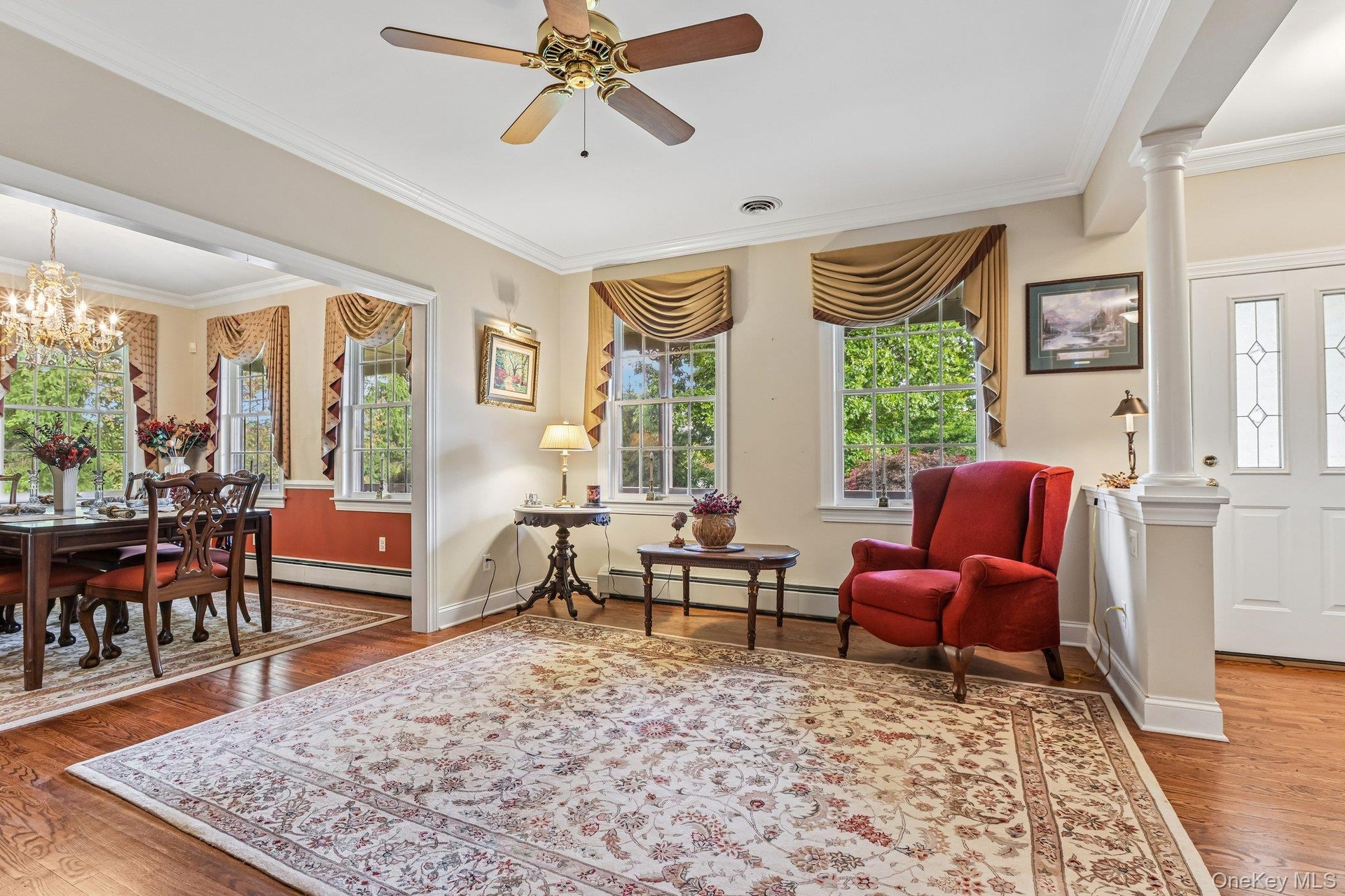 Wood-finish flooring, crown molding, and a ceiling fan with integrated lighting