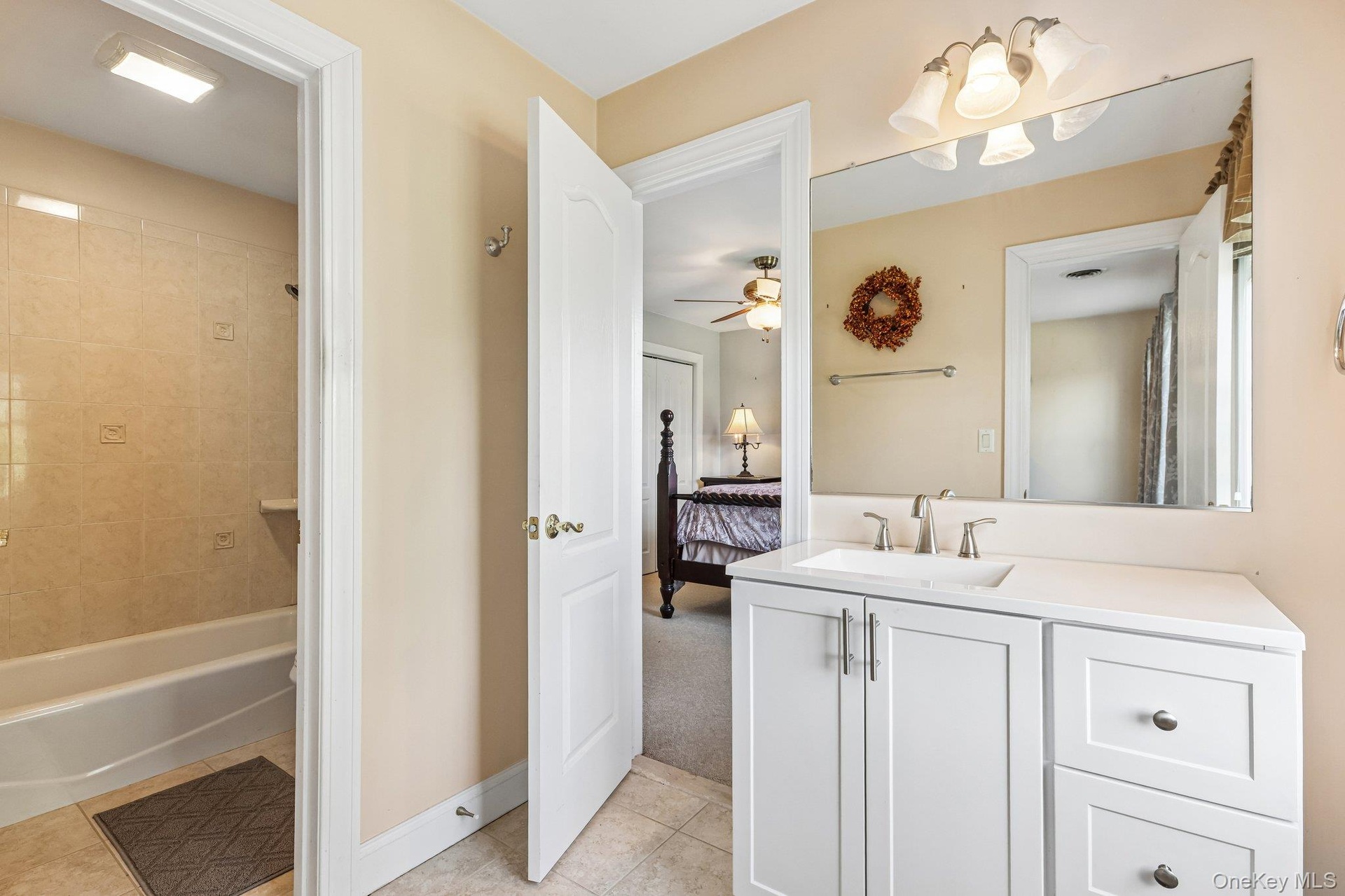Bathroom vanity with a white countertop, undermount sink, and brushed nickel faucet