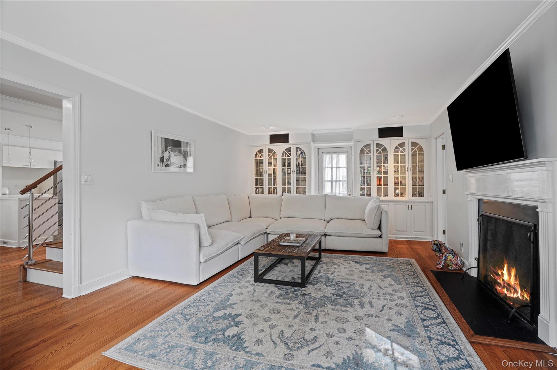 Living Room With Wood Burning Fireplace & French Door To Deck