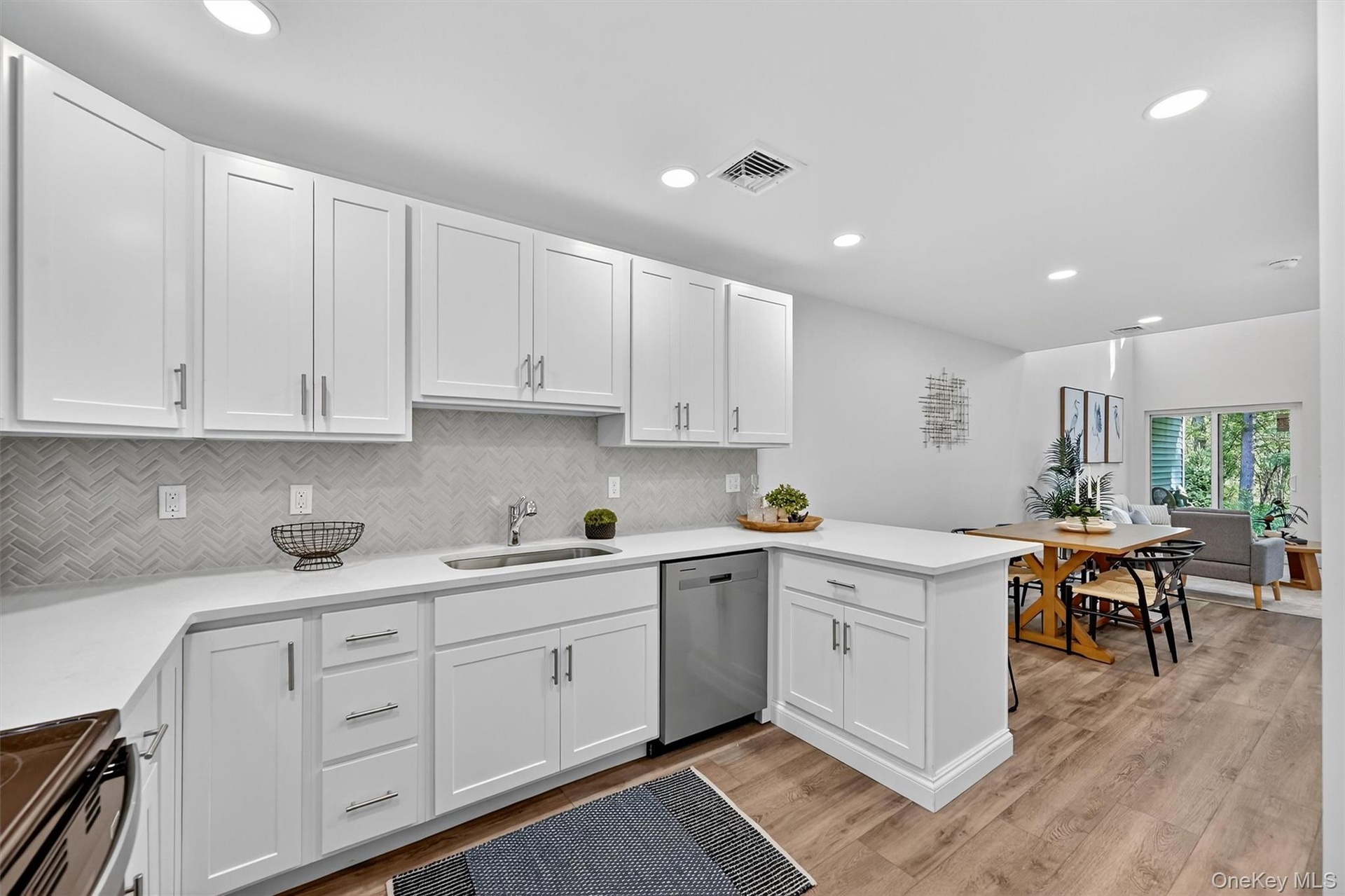 Kitchen with white cabinets, backsplash, dishwasher, black range with electric stovetop, and recessed lighting
