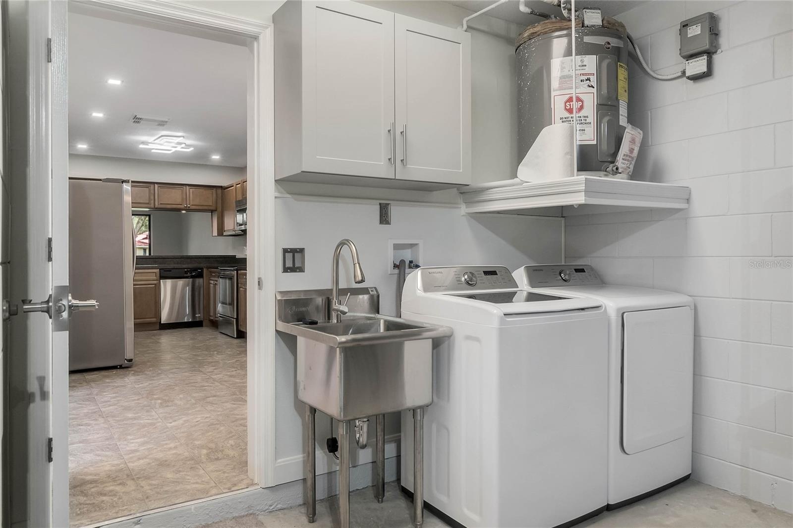 Garage laundry area with washer and dryer space and a utility sink for added convenience.