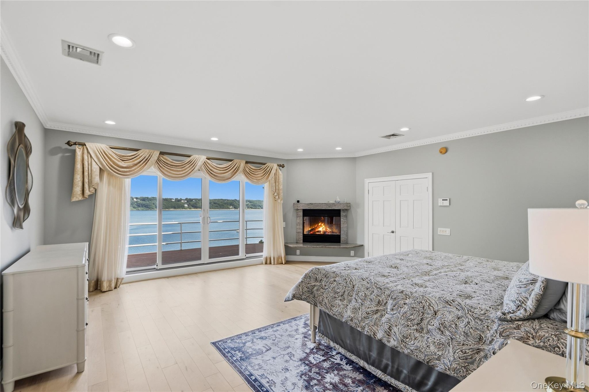 Primary Bedroom with fireplace, balcony and water views