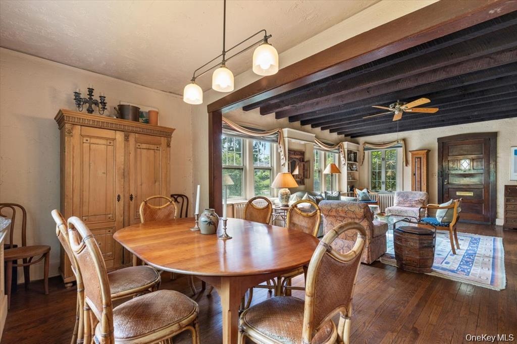 Dining area with hardwood / wood-style floors, beamed ceiling, and ceiling fan