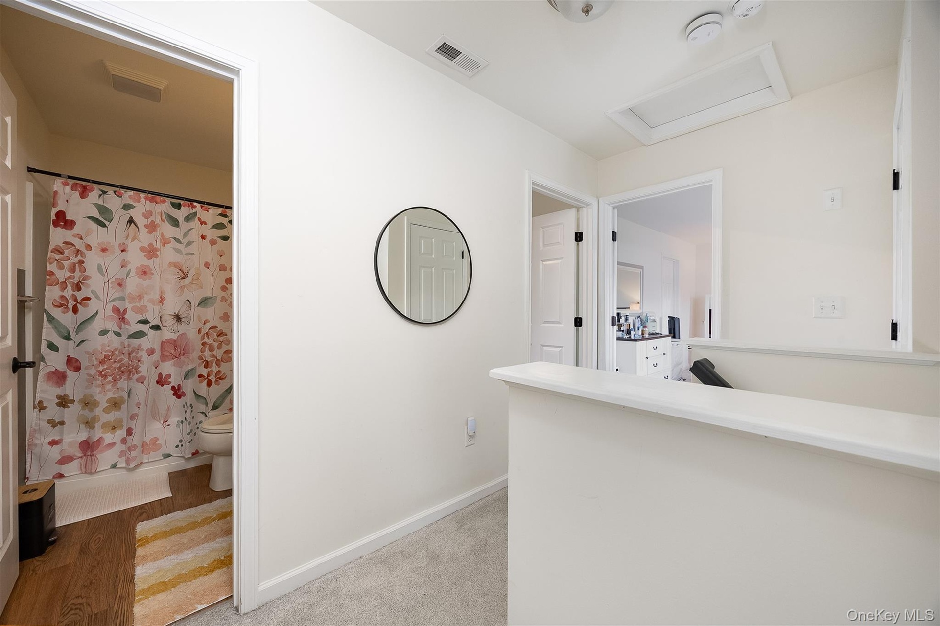 Interior hallway with carpet flooring and light-toned walls