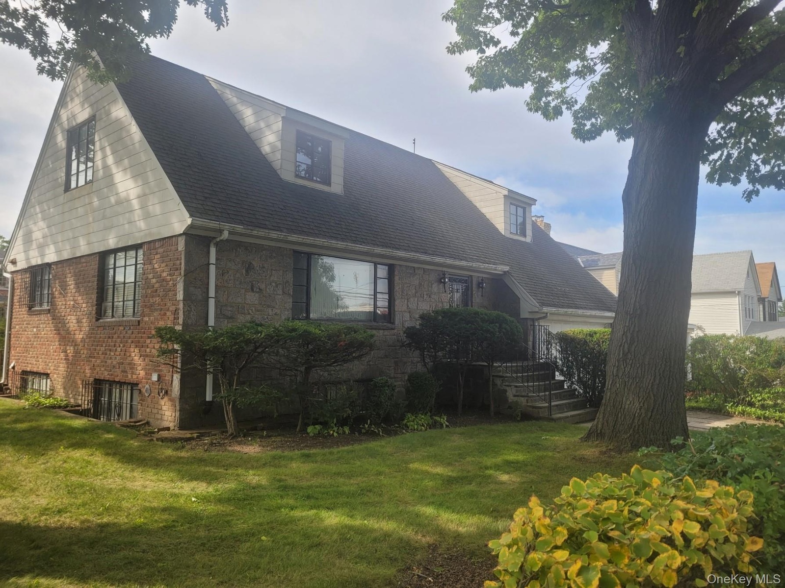 Brick and shingle exterior with a gabled roofline and dormer windows