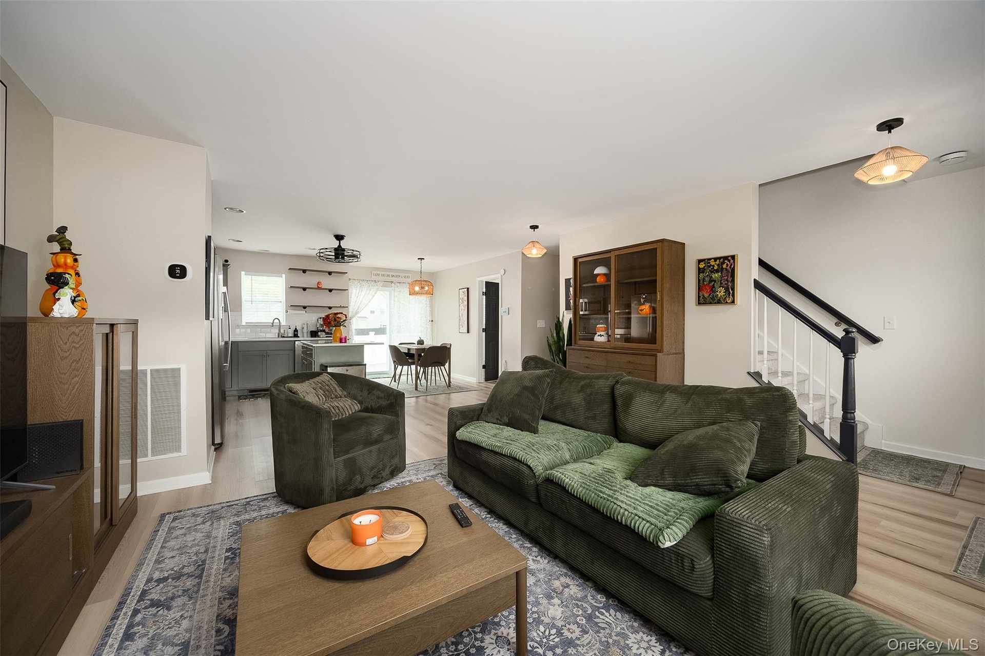 Open-concept living area with vinyl plank flooring, a built-in staircase, and recessed lighting