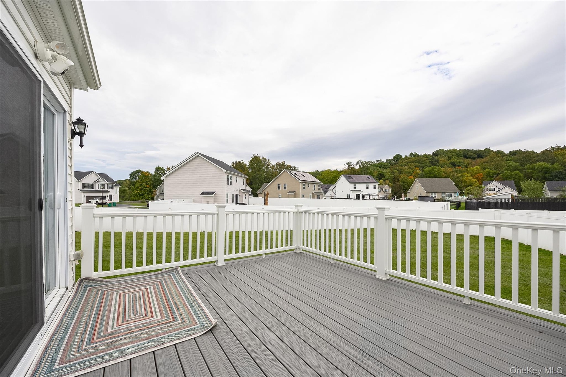 Spacious deck with gray composite decking, white railing, and sliding glass door