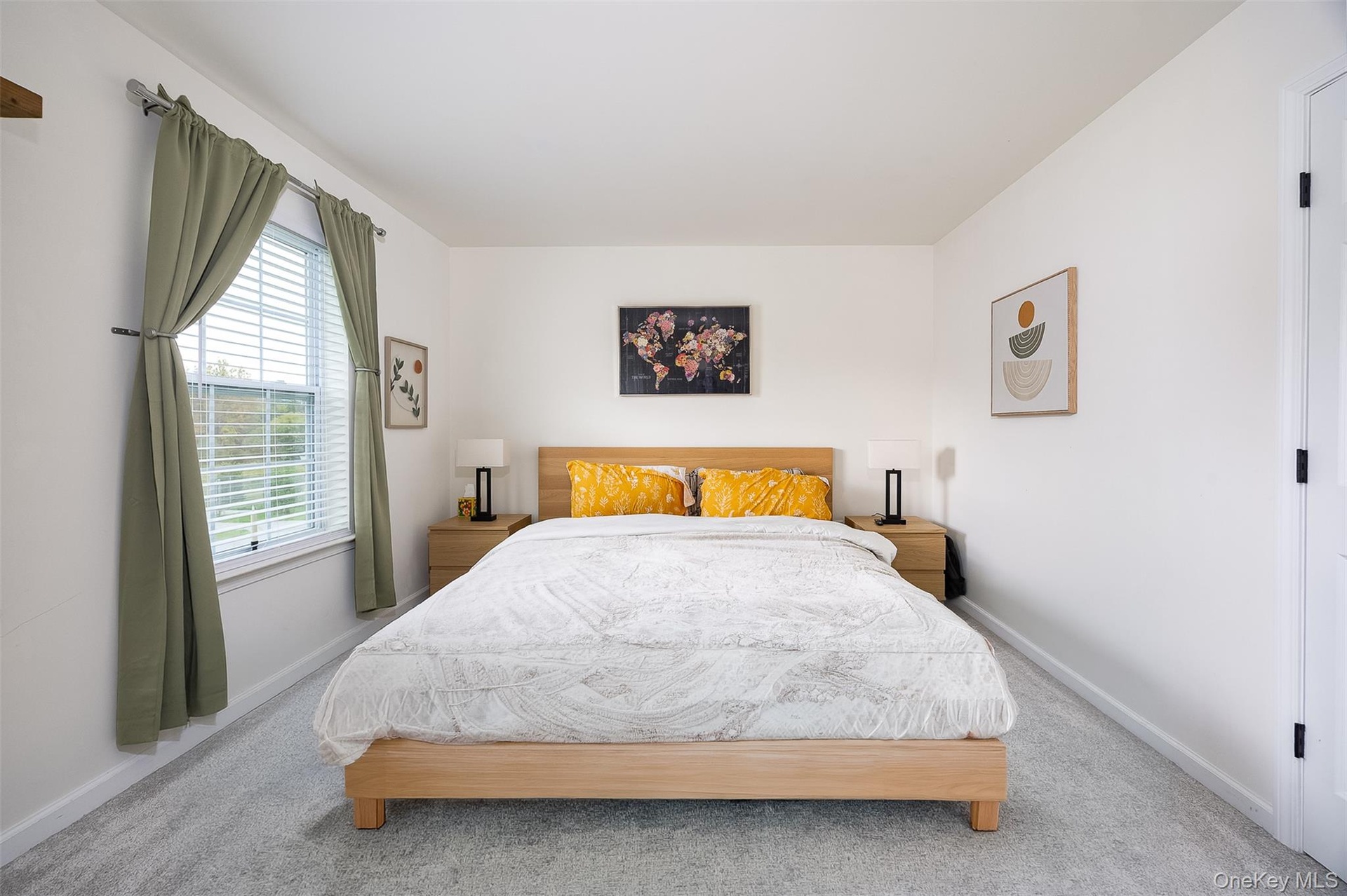 Expansive room with neutral carpeting, white walls, and a large window with blinds