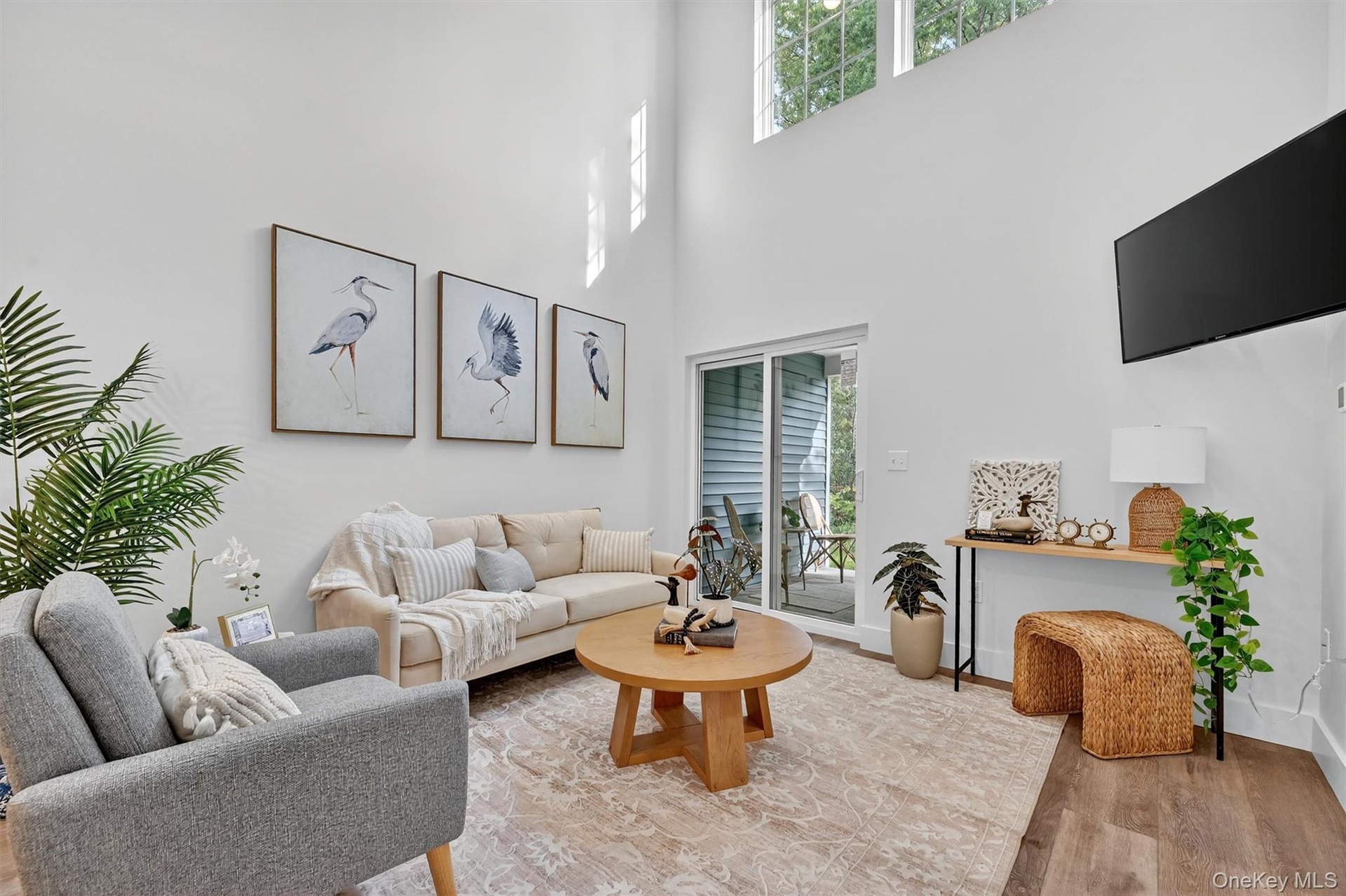 Living room featuring light wood finished floors and a towering ceiling