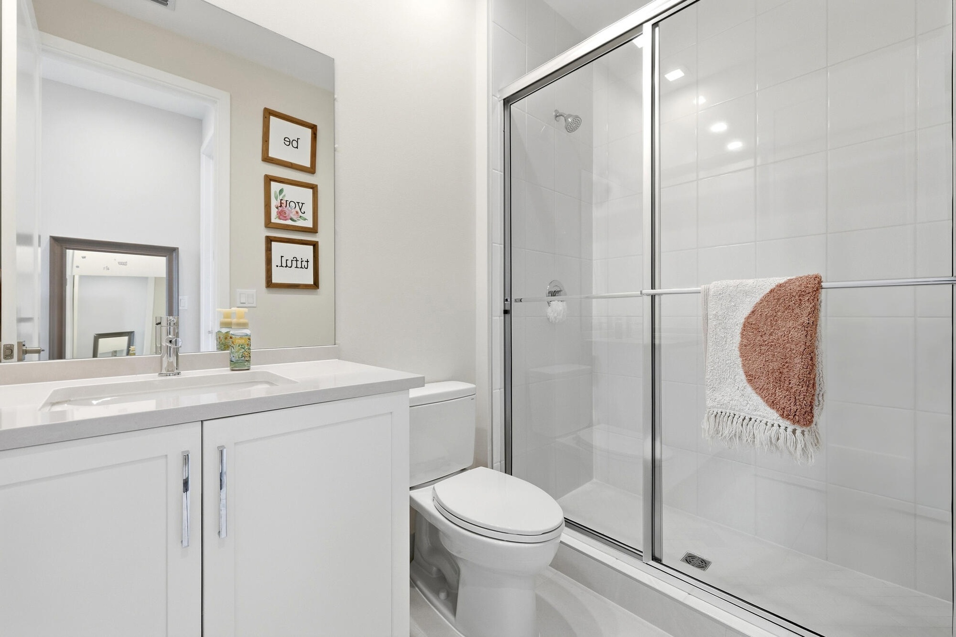 White vanity with an integrated sink, polished chrome faucet, and spacious countertop