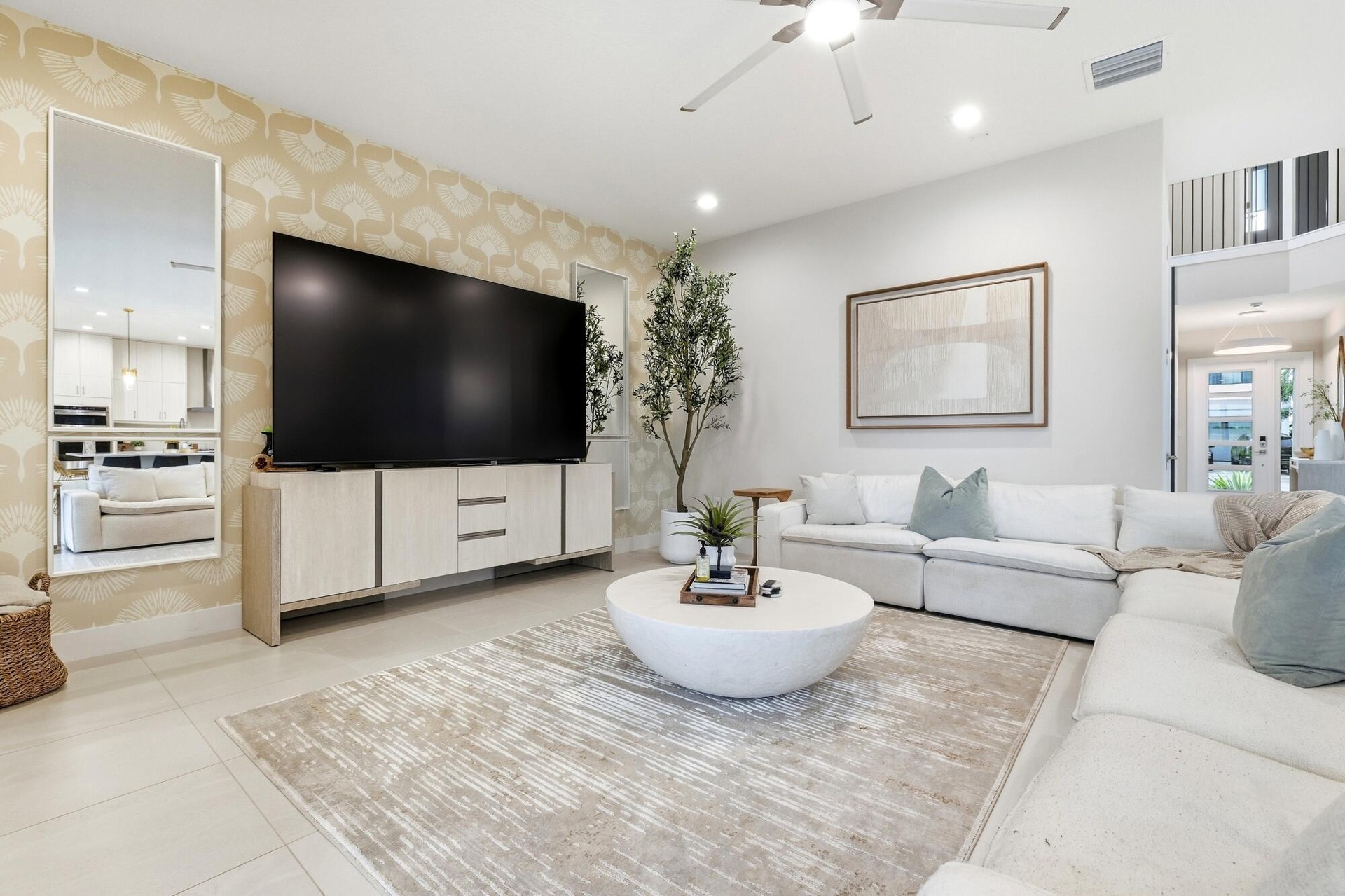 Recessed ceiling lighting, a modern ceiling fan, tall ceilings, and light-toned tile flooring