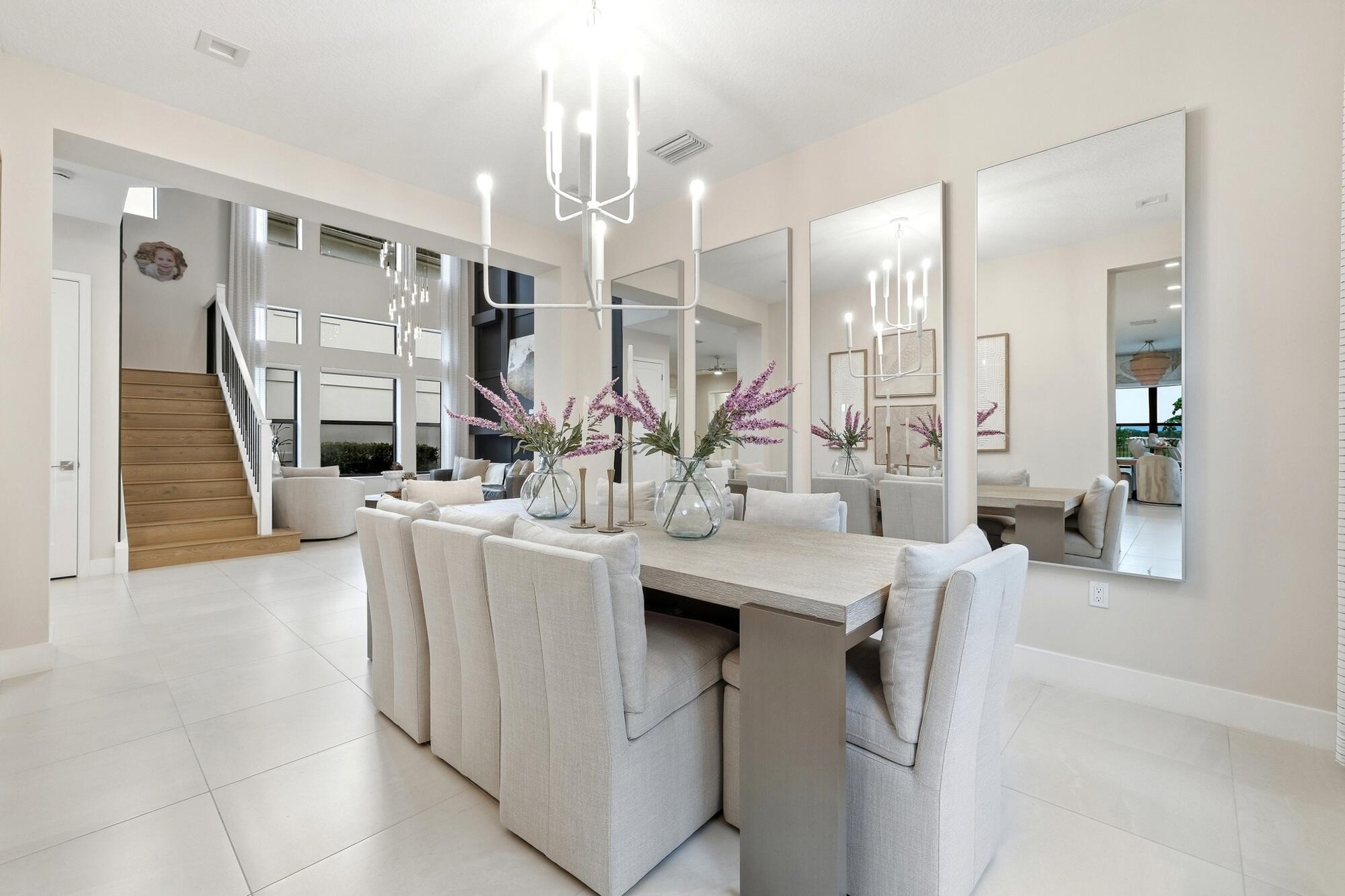 Open-concept dining area featuring a light-toned dining table and white tile flooring