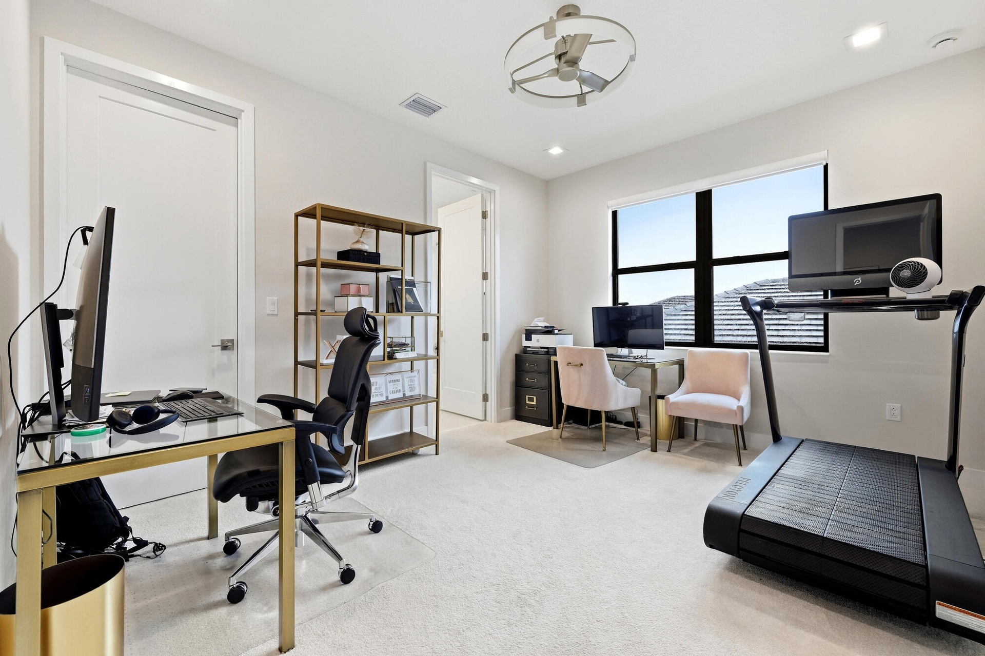 Bright interior space featuring a large window, recessed lighting, ceiling fan, and light-toned carpeting