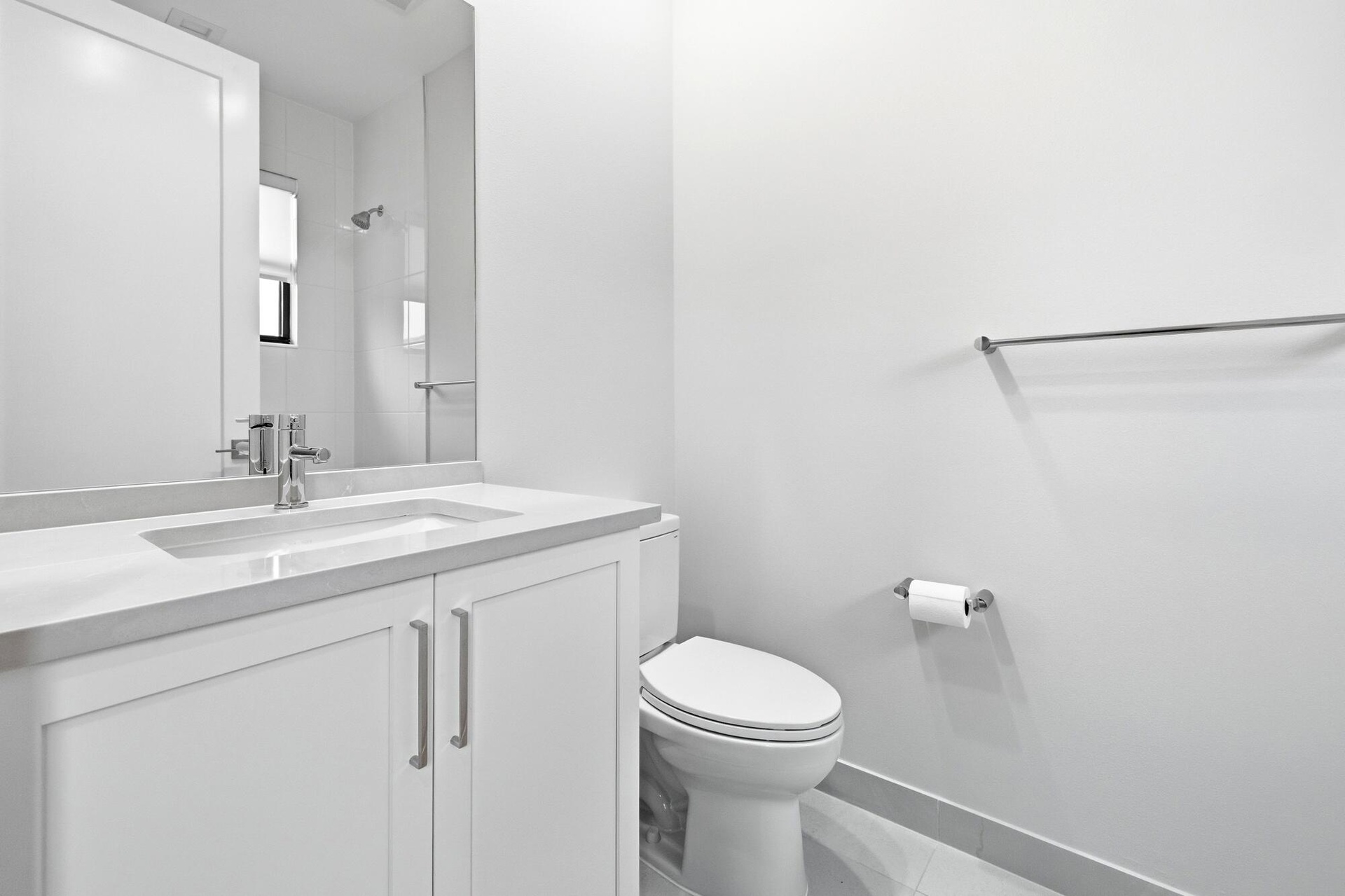 White vanity with an integrated sink, polished chrome faucet, and coordinating hardware