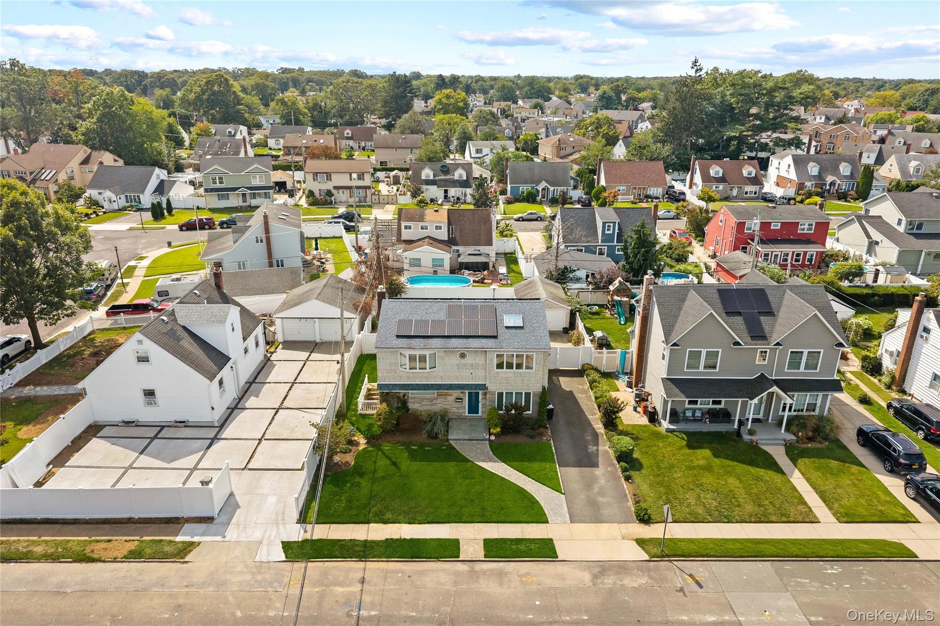 Well-maintained lawn, solar panels, and extensive concrete paving