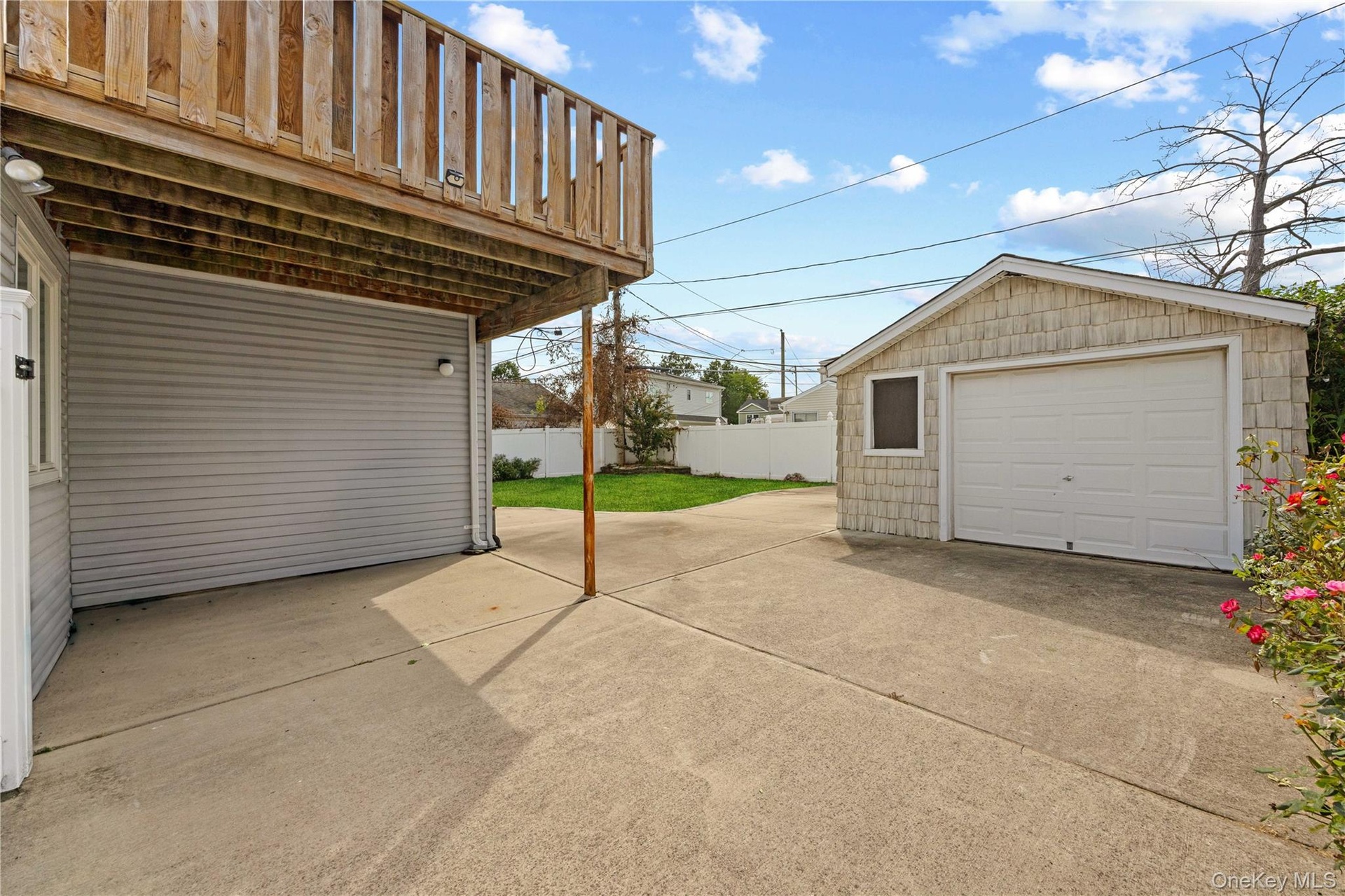 Exterior concrete patio with an overhead wood-plank deck
