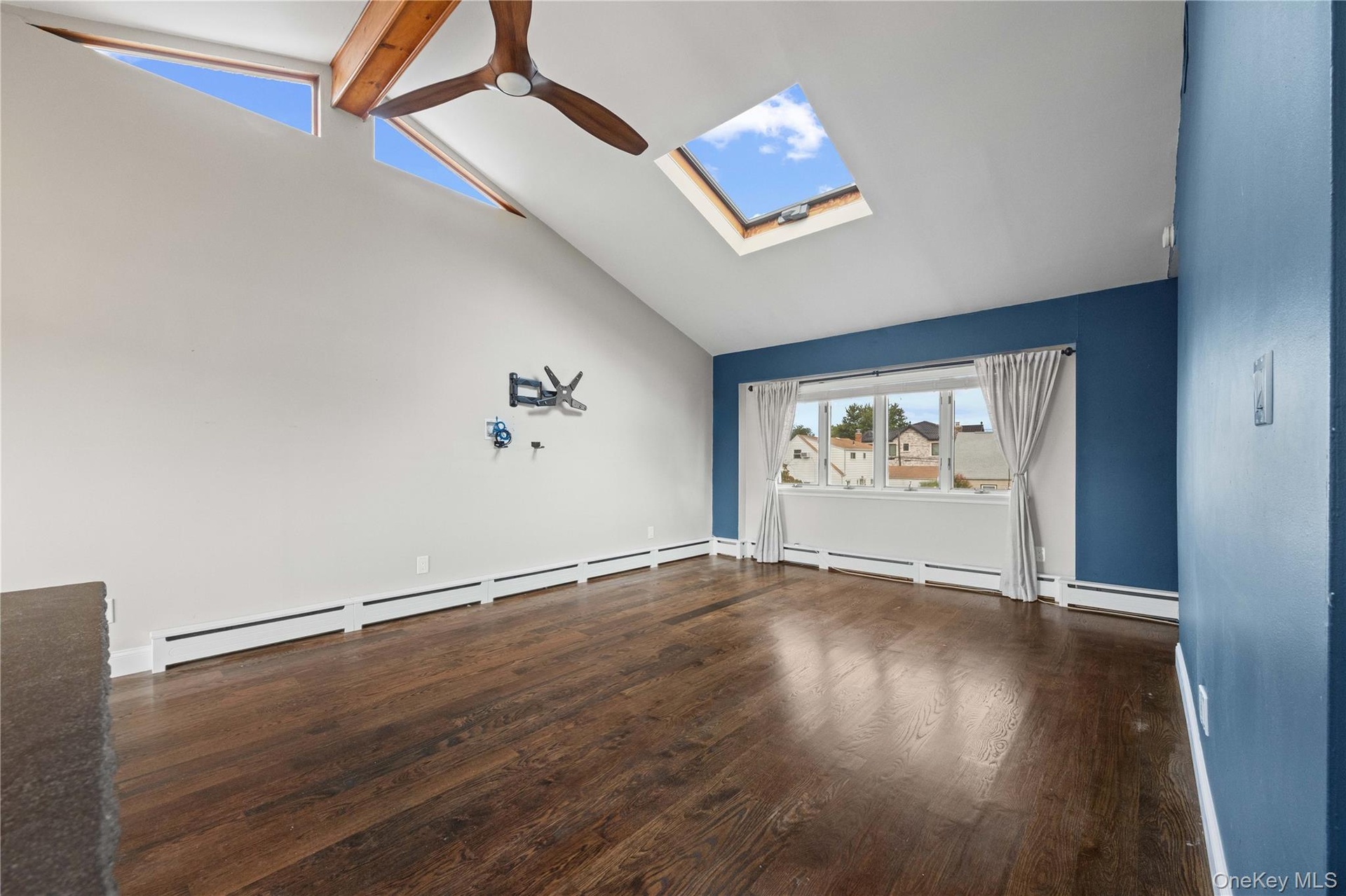 Vaulted ceiling featuring exposed wood beams and a ceiling fan