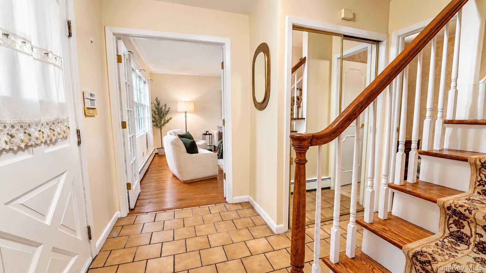The welcoming foyer features tile flooring, a convenient coat closet, and easy access to the spacious living room, family room, and secondary bedroom 