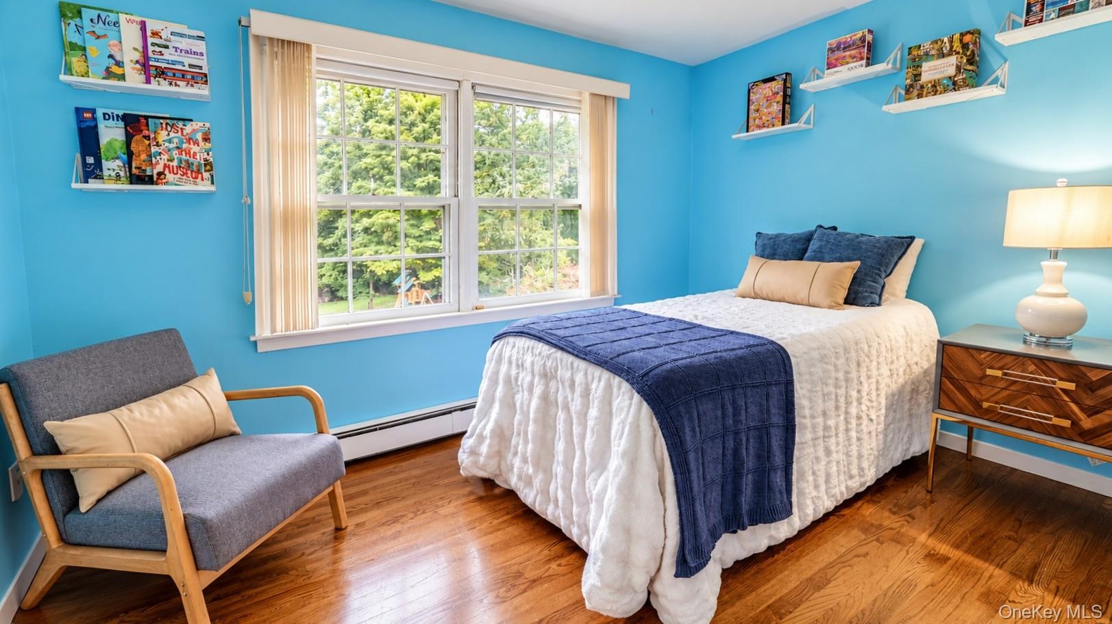 The spacious third bedroom features bookshelves and an abundance of natural light, creating a bright and inviting space ideal for a bedroom and home s